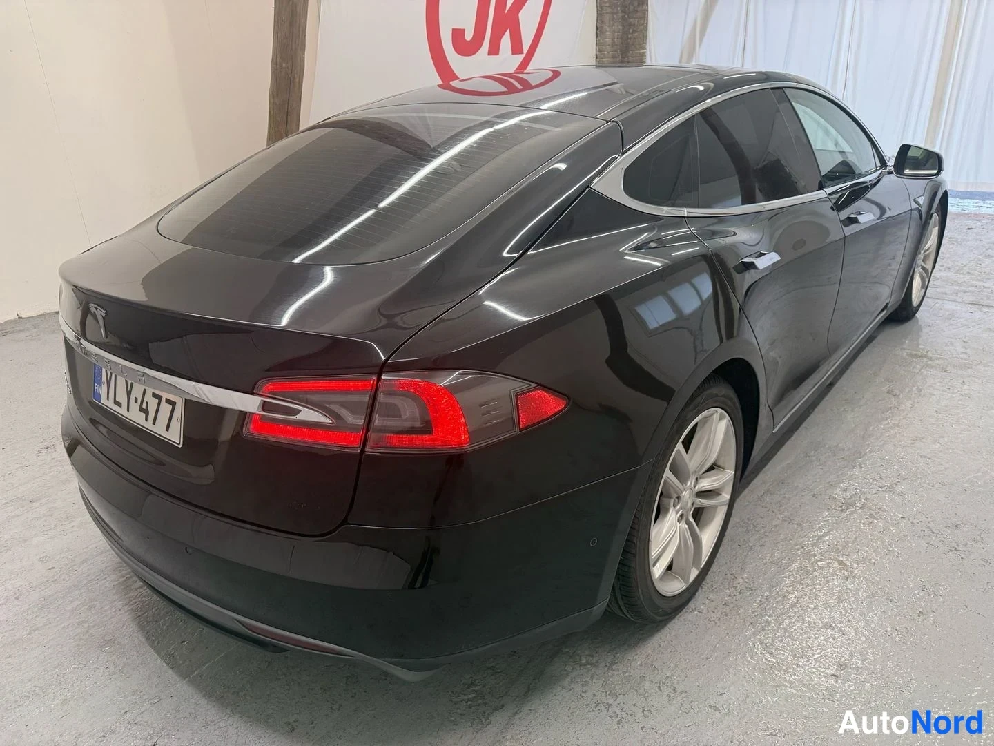 Takaviisto: Musta Tesla Model S takana ja oikealta sivulta, rekisterikilpi, hopeiset kevytmetallivanteet.