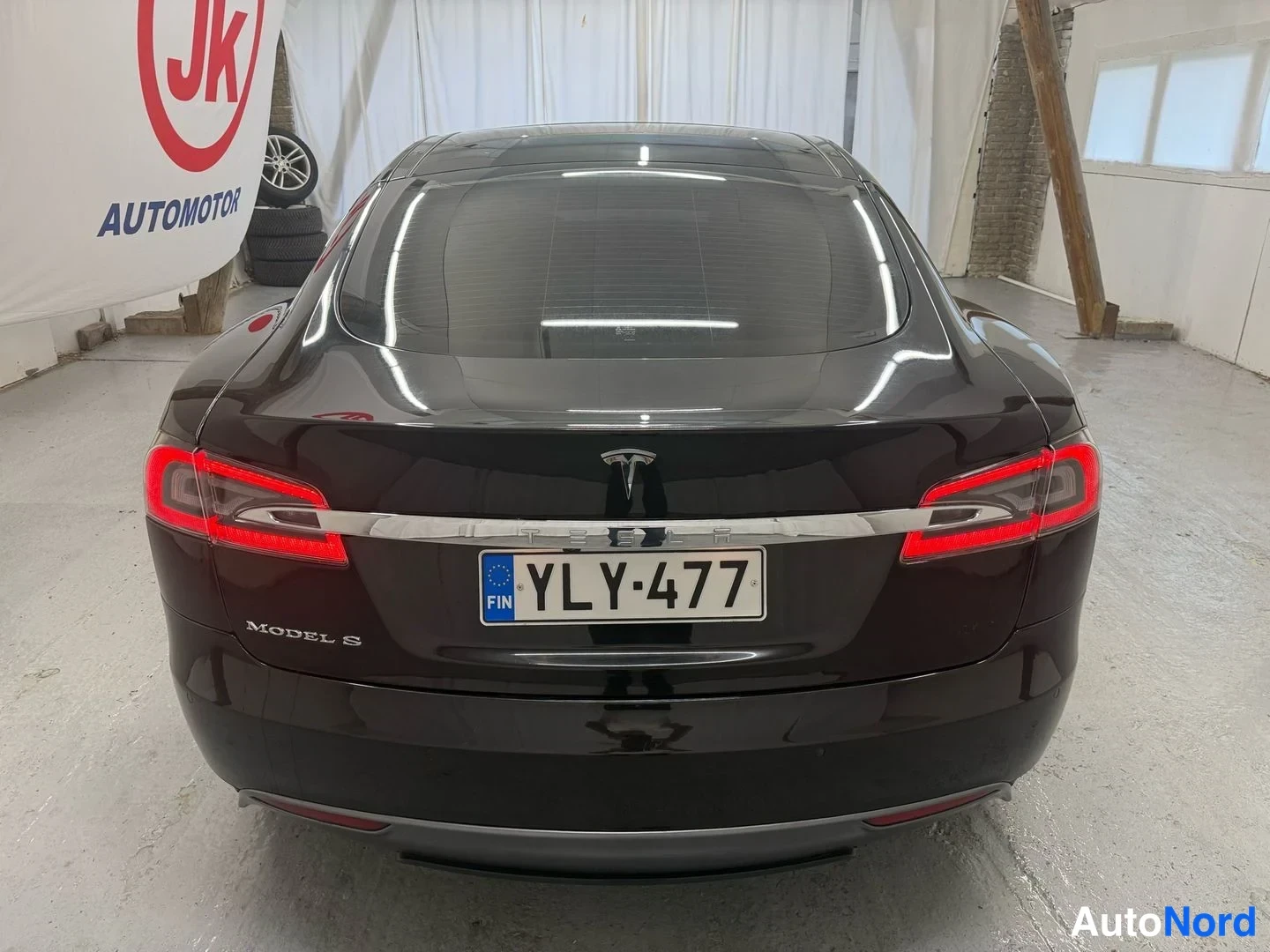 Takaa: Tesla Model S suoraan takaa, punaiset takavalot, rekisterikilpi FIN ja tavaratilan kannessa teksti MODEL S.