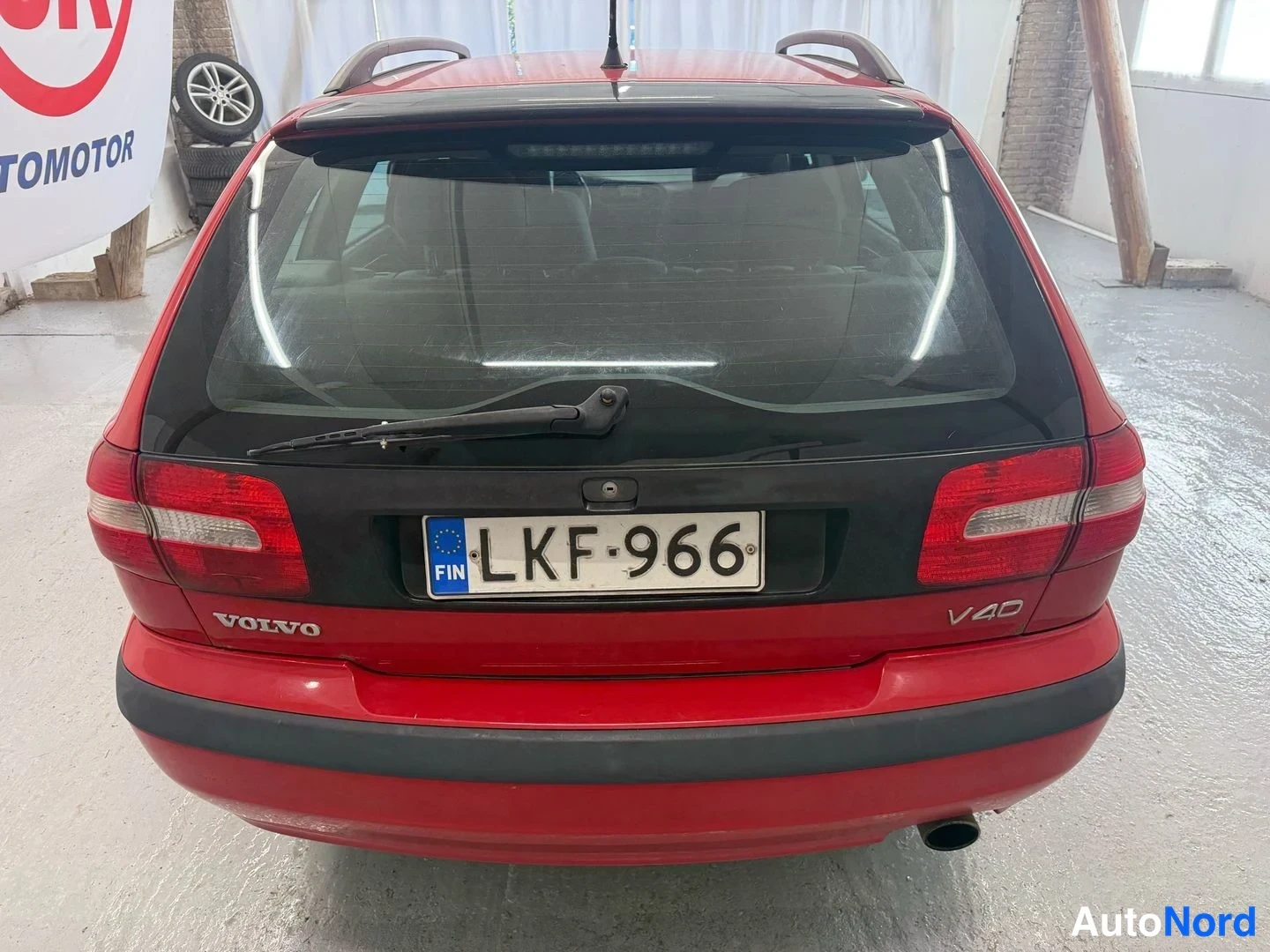 Takaa: Punaisen Volvo V40 -farmarin takaosa suoraan takaa; VOLVO- ja V40-merkinnät, takatuhkruisku ja -rekisterikilpi näkyvät.