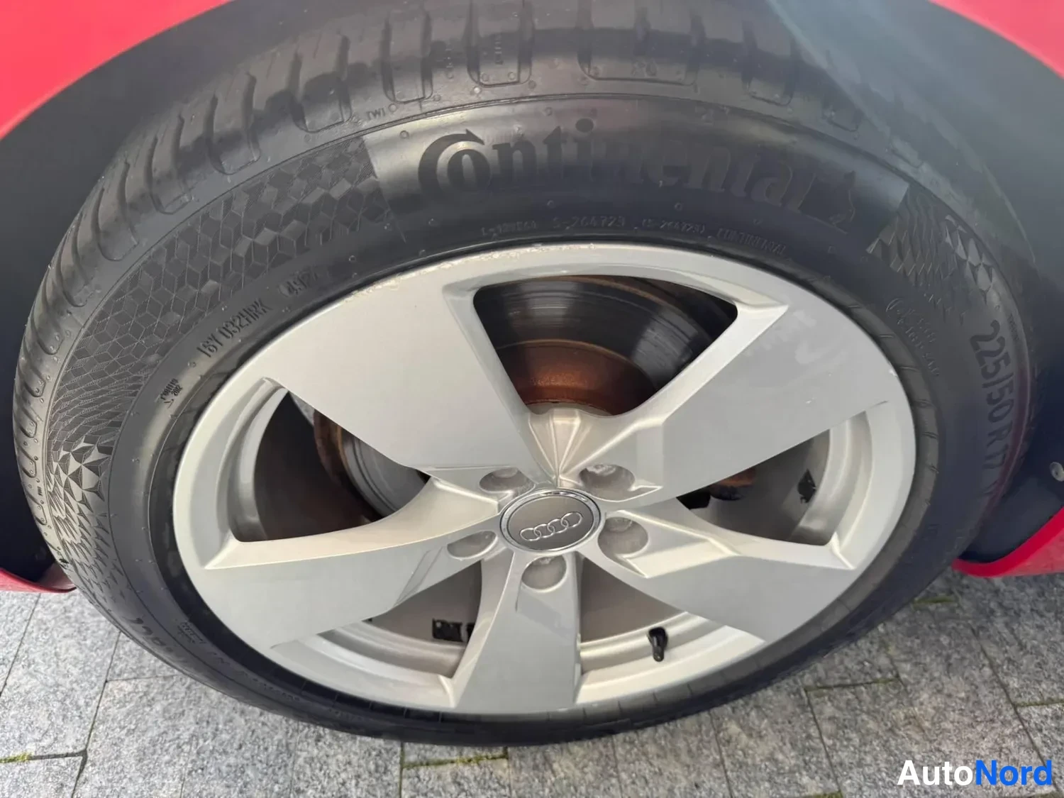 Yksityiskohta: Audi'n hopeinen viisipuolainen alumiinvanne ja Continental-renkaaseen painettu merkintä 225/50 R17 lähikuvassa