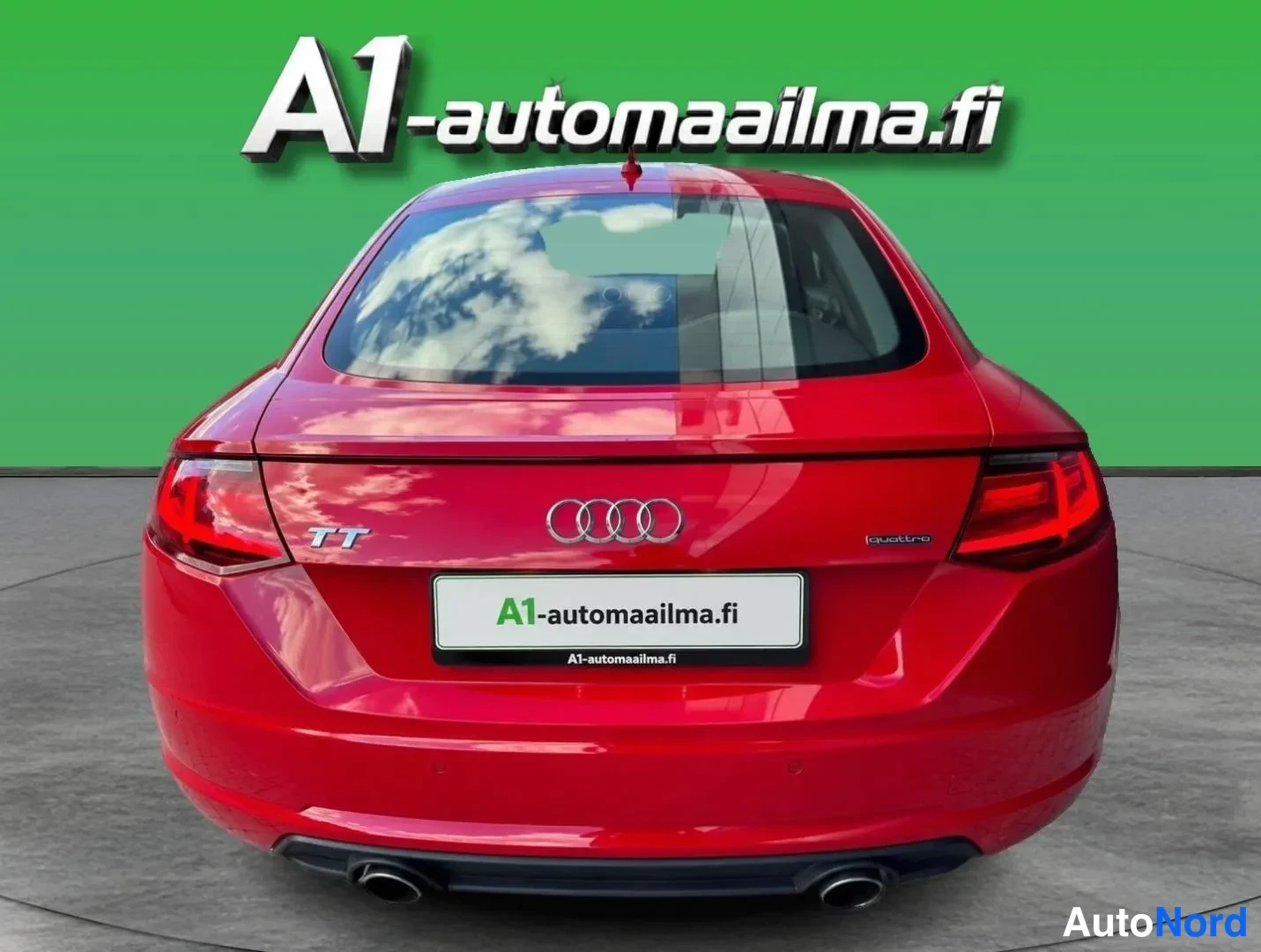Takaa: Punainen Audi TT Coupé suoraan takaa, takavalot, TT-merkintä ja kaksi pakoputkea näkyvät.