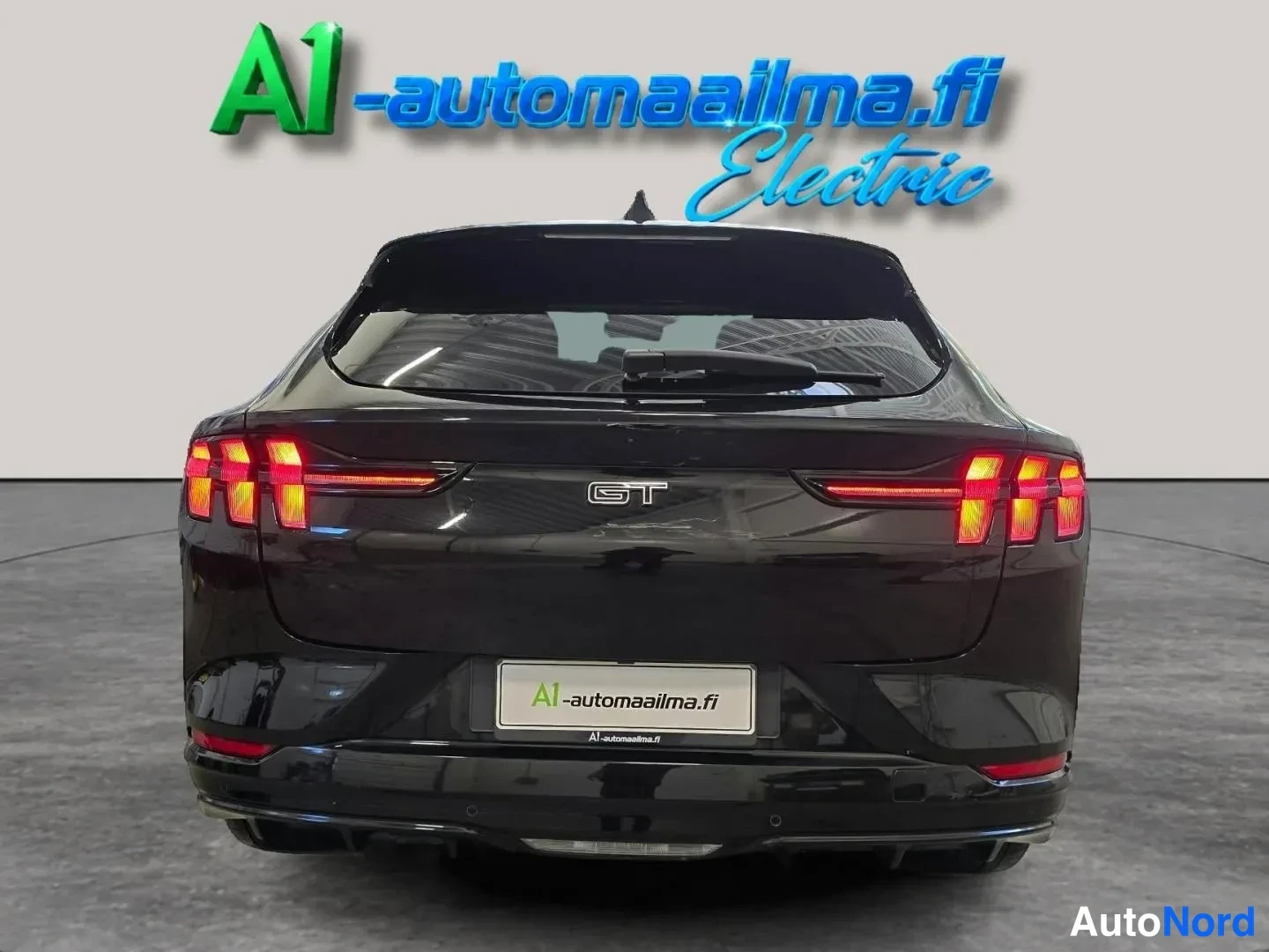 Takaa: Mustan Ford Mustang Mach-E:n takapää suoraan takaa, kolmiosaiset takavalot ja GT-merkki näkyvät.