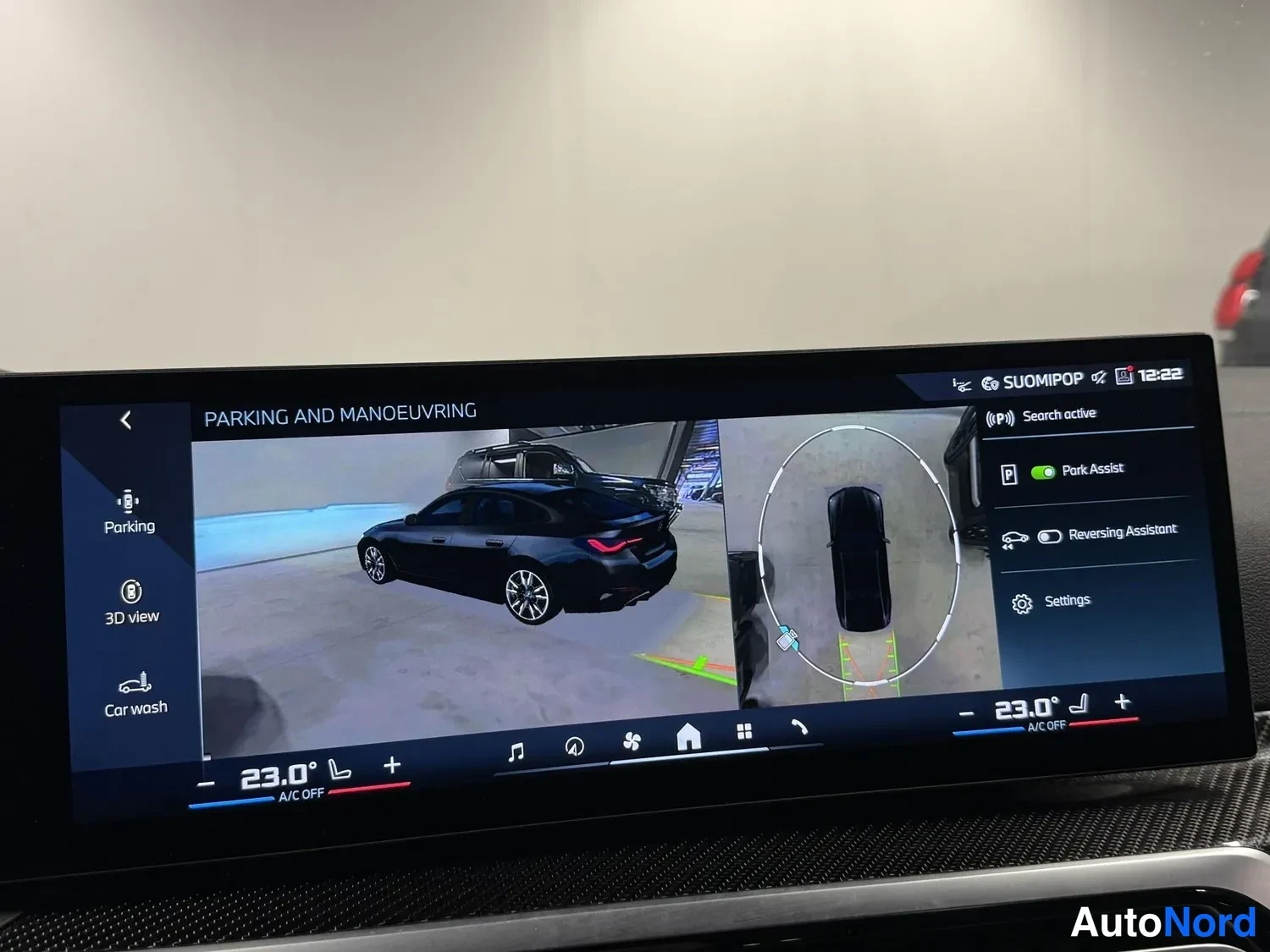 Muu: Näytön 3D-näkymä parkkitilanteesta: musta autokuvake ja valikot Park Assist, Reversing Assistant ja Settings, lämpötila 23,0°, kello 12:22.