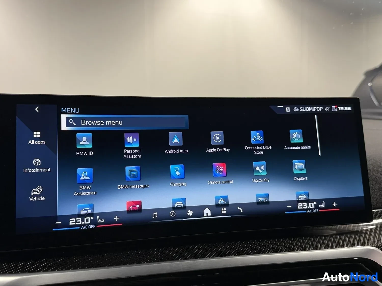 Muu: Auton infotainment-näytön valikko sovelluskuvakkeineen: Android Auto, Apple CarPlay, Charging, Climate control ja Digital Key, taustalla SUOMIPOP ja kello 12:22