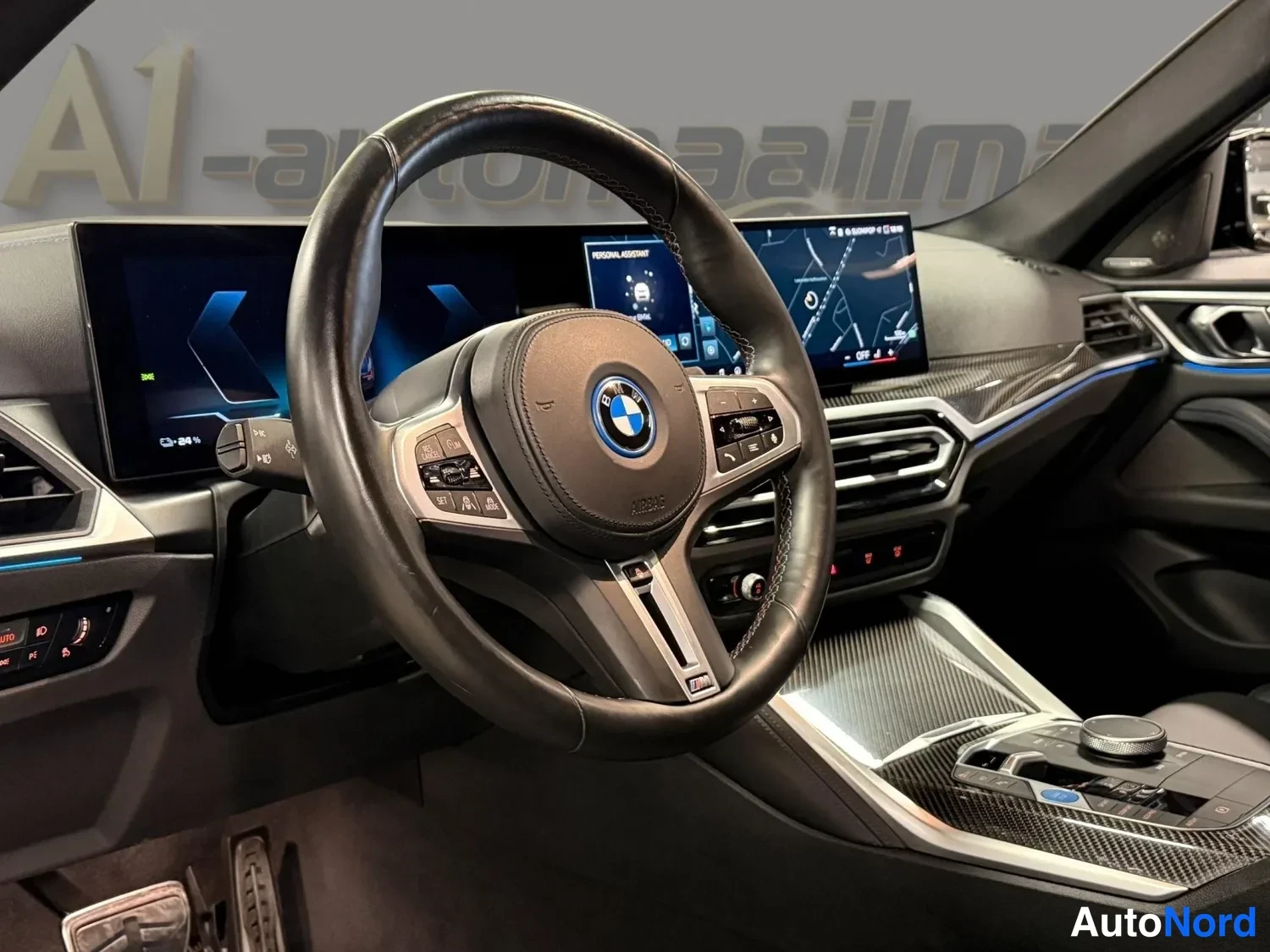 Edestä: Kojelaudan näkymä: BMW-ohjauspyörä, laaja näytön kokoonpano ja hiilikuitukoristeet