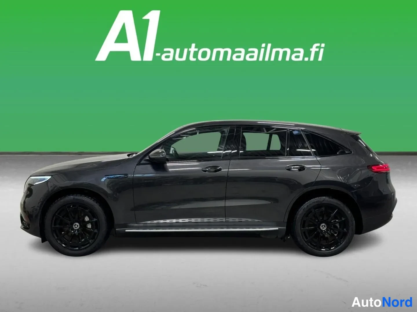 Etuviisto, nokka vasemmalle: Tummanharmaan Mercedes EQC -maasturin vasen kylki kokonaisuudessaan; mustat kevytmetallivanteet ja kromilista ovien alla erottuvat selkeästi.