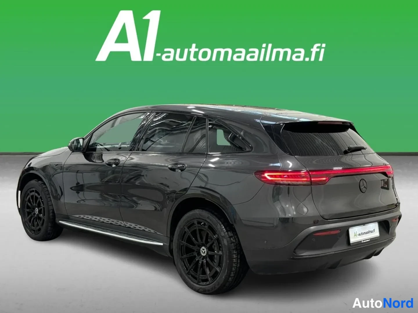 Takaviisto: Tummanharmaan Mercedes EQC:n takaosa ja vasen kylki kulmakuvassa; poikittainen punainen takavalot ja black-vanteet näkyvät selvästi.