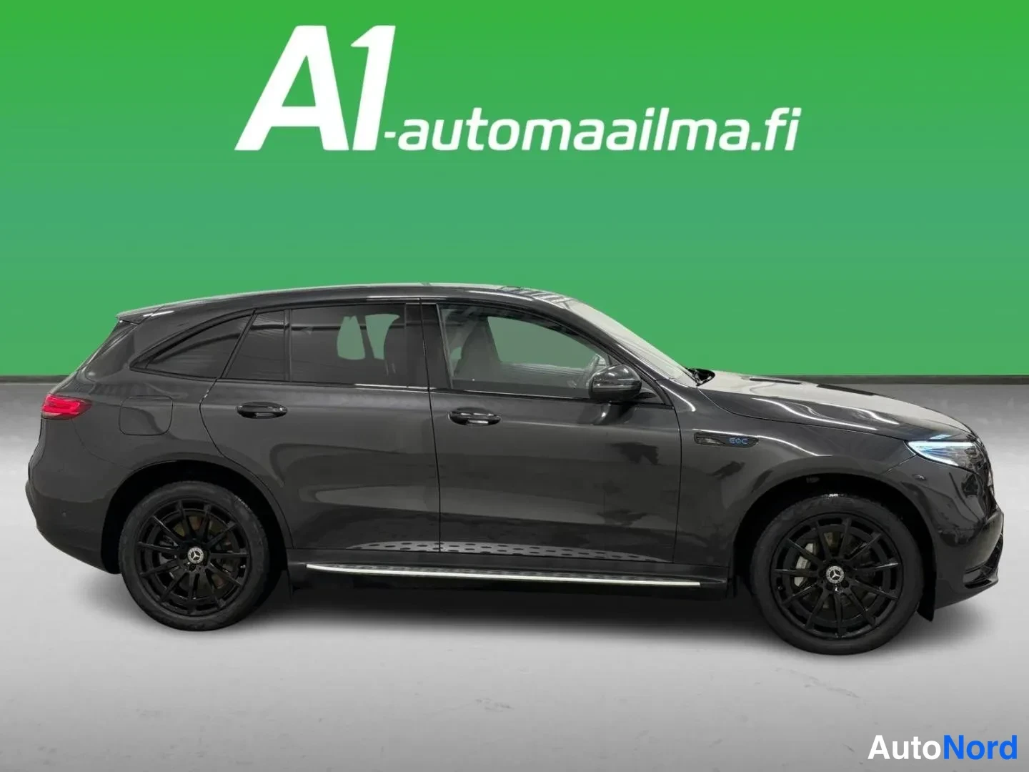 Sivulta: Sivukuva tummanharmaasta Mercedes-Benz EQC -maasturista, näkyvät ovet, mustat vanteet ja kromilista studio-taustaa vasten.
