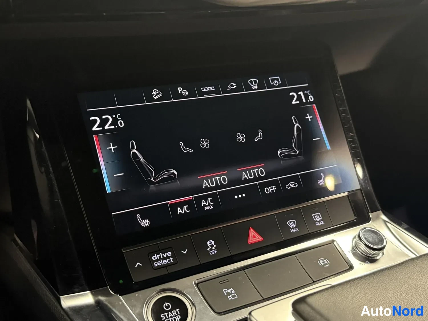 Muu: Audi e-tronin keskikonsolin kosketusnäyttö näyttää kaksialueisen ilmastoinnin asetukset (22,0 °C ja 21,0 °C, AUTO), A/C ja A/C MAX -painikkeet sekä alla drive s