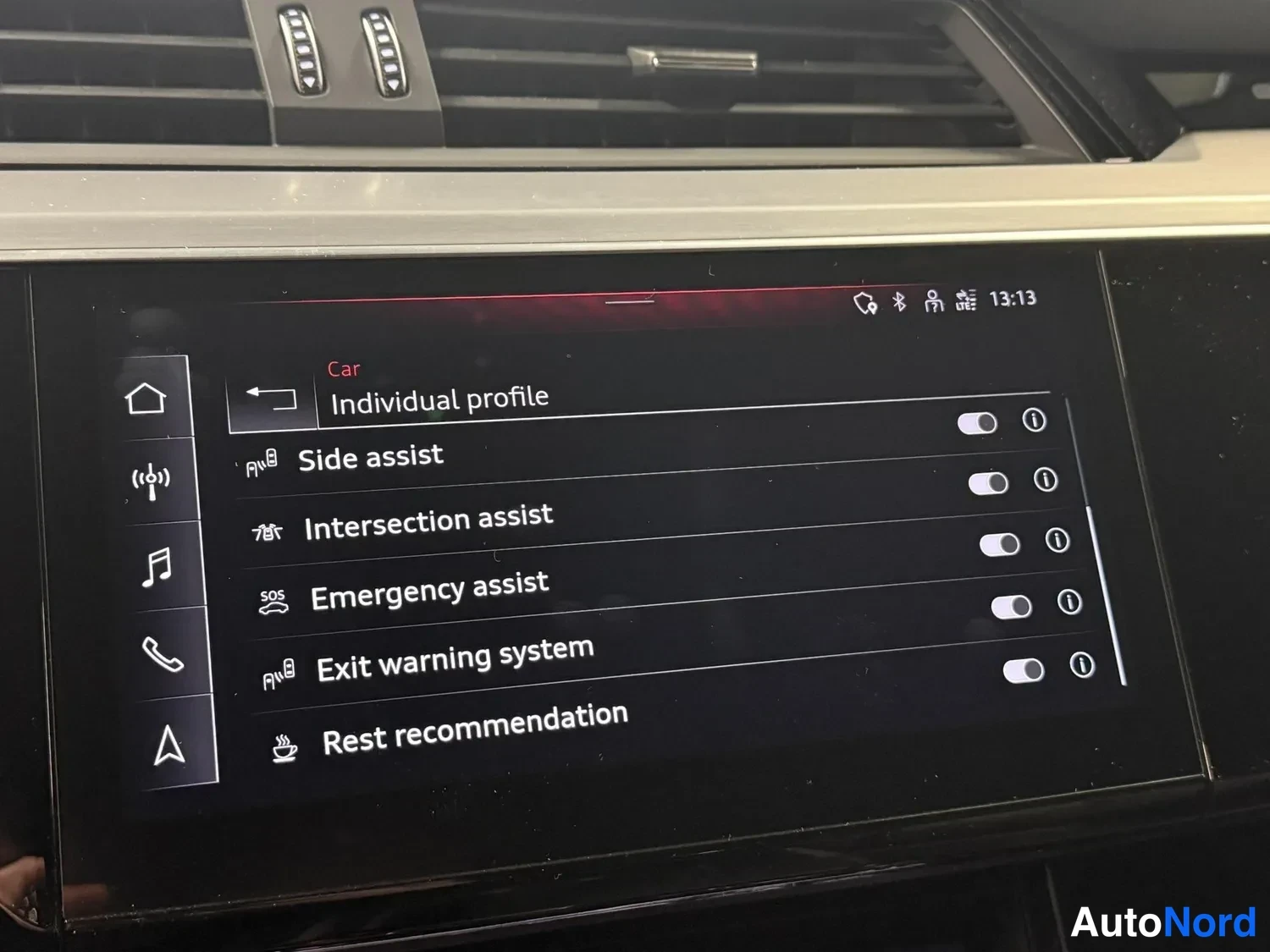 Muu: Auton keskusnäytön valikko, jossa näkyvät Side assist - ja Exit warning -asetukset.