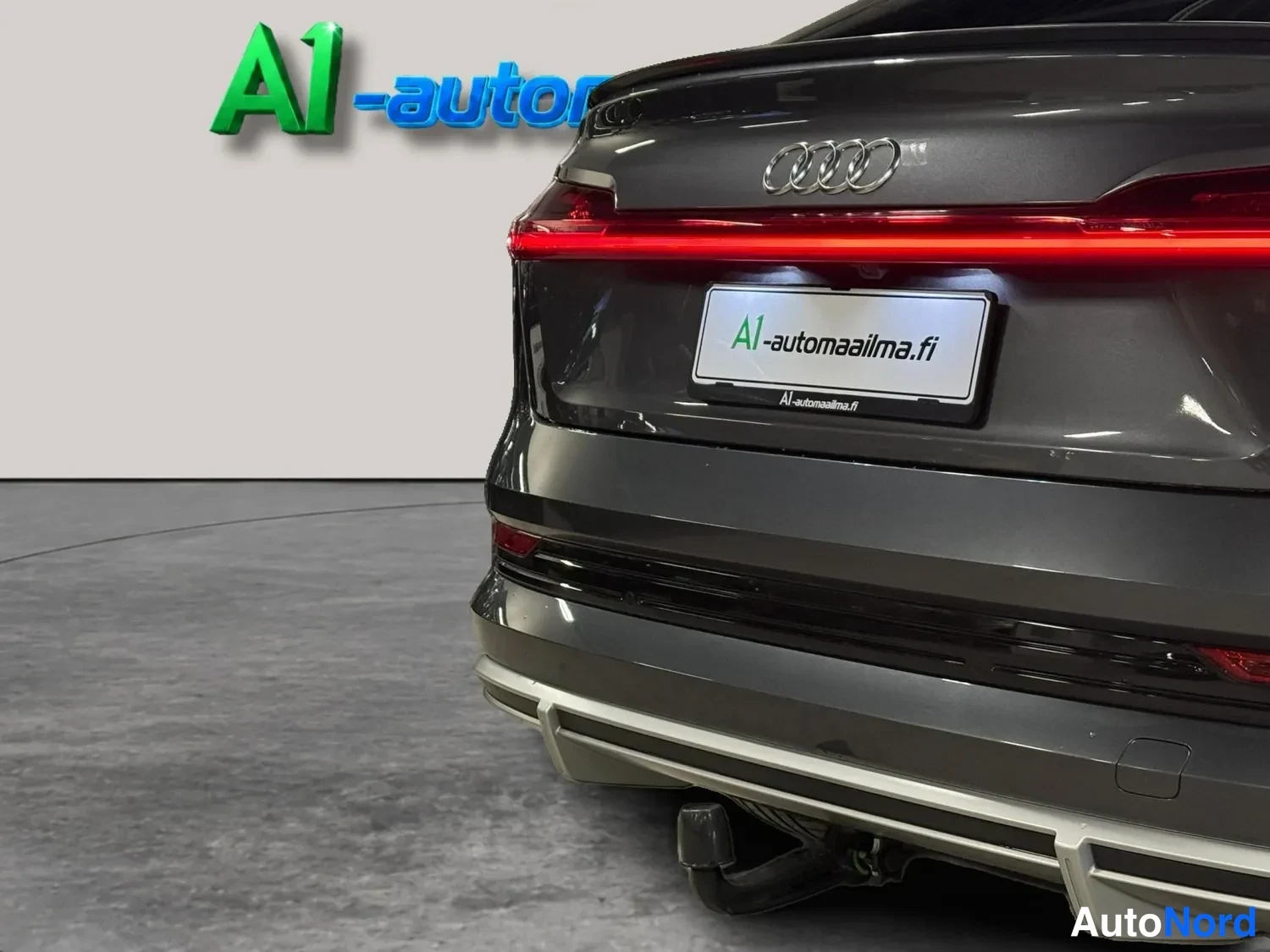 Takaa: Audi e-tronin takaosan lähikuva punaisella valoviivalla ja vetoaisalla