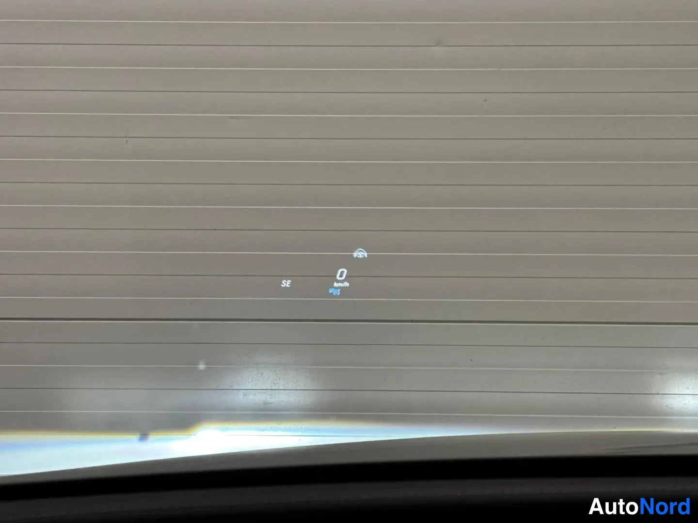 Muu: Tuulilasiin heijastettu näyttö, jossa teksti SE, nopeus 0 km/h ja assistenttien kuvake