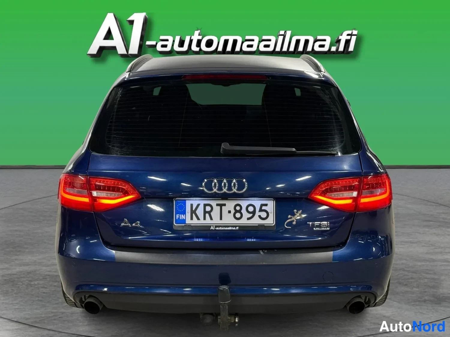 Takaa: Sinisen Audi A4:n takaosan suora takanäkymä, rekisterikilpi, neljästöpakoputket ja vetokoukku näkyvissä.