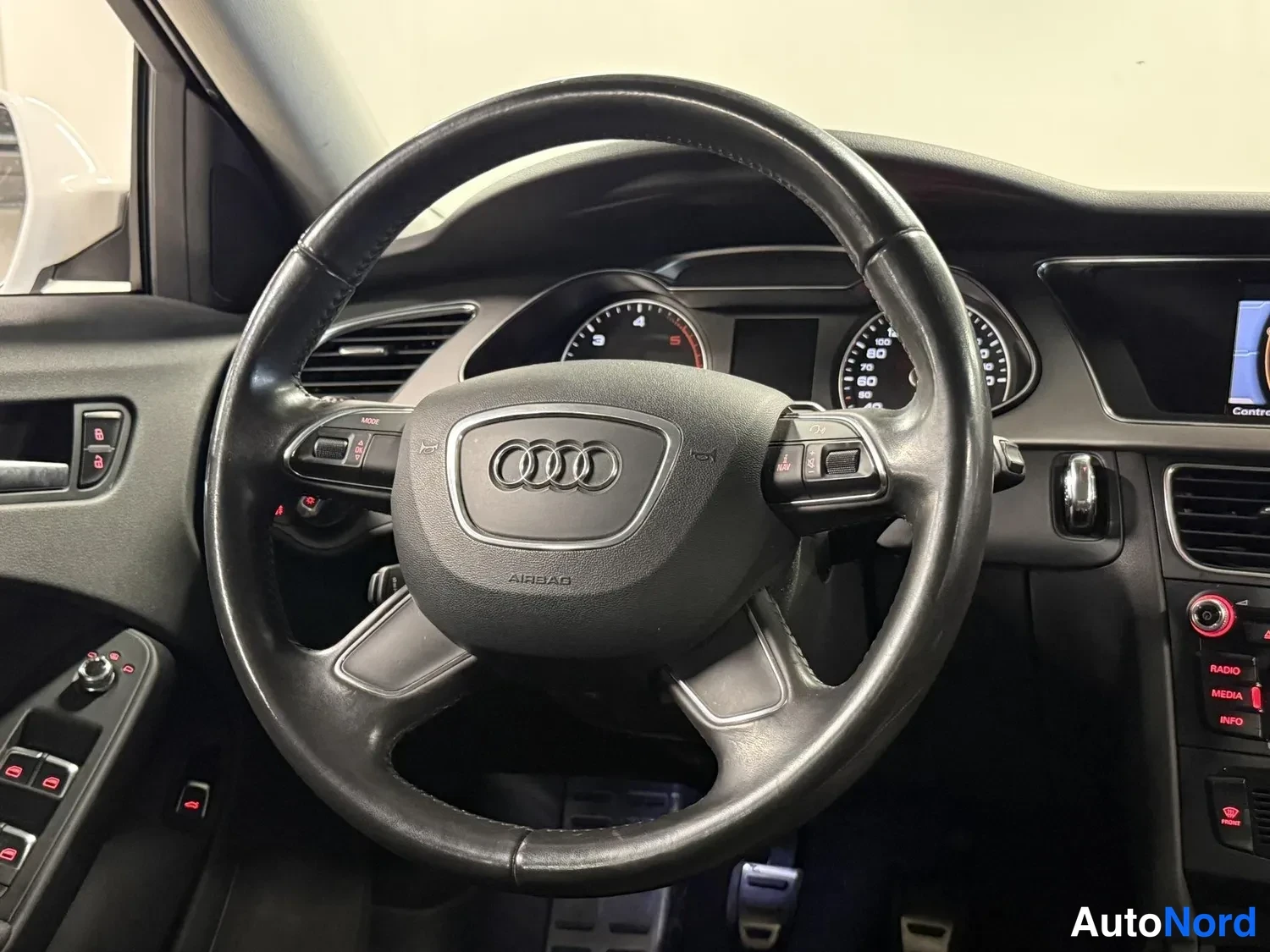 Muu: Ohjauspään näkymä: musta Audi-ohjauspyörä, mittaristo ja osa kojelautaa.