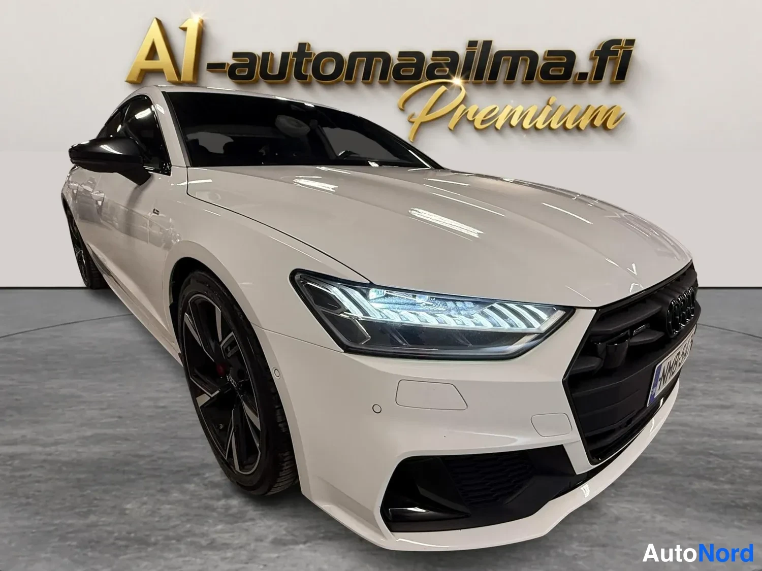 Etuviisto, nokka oikealle: Valkoinen Audi A7 Sportback kuvattu etuosaltaan kolmannen pauksen kulmasta, LED-ajovalot ja musta etusäleikkö näkyvissä.
