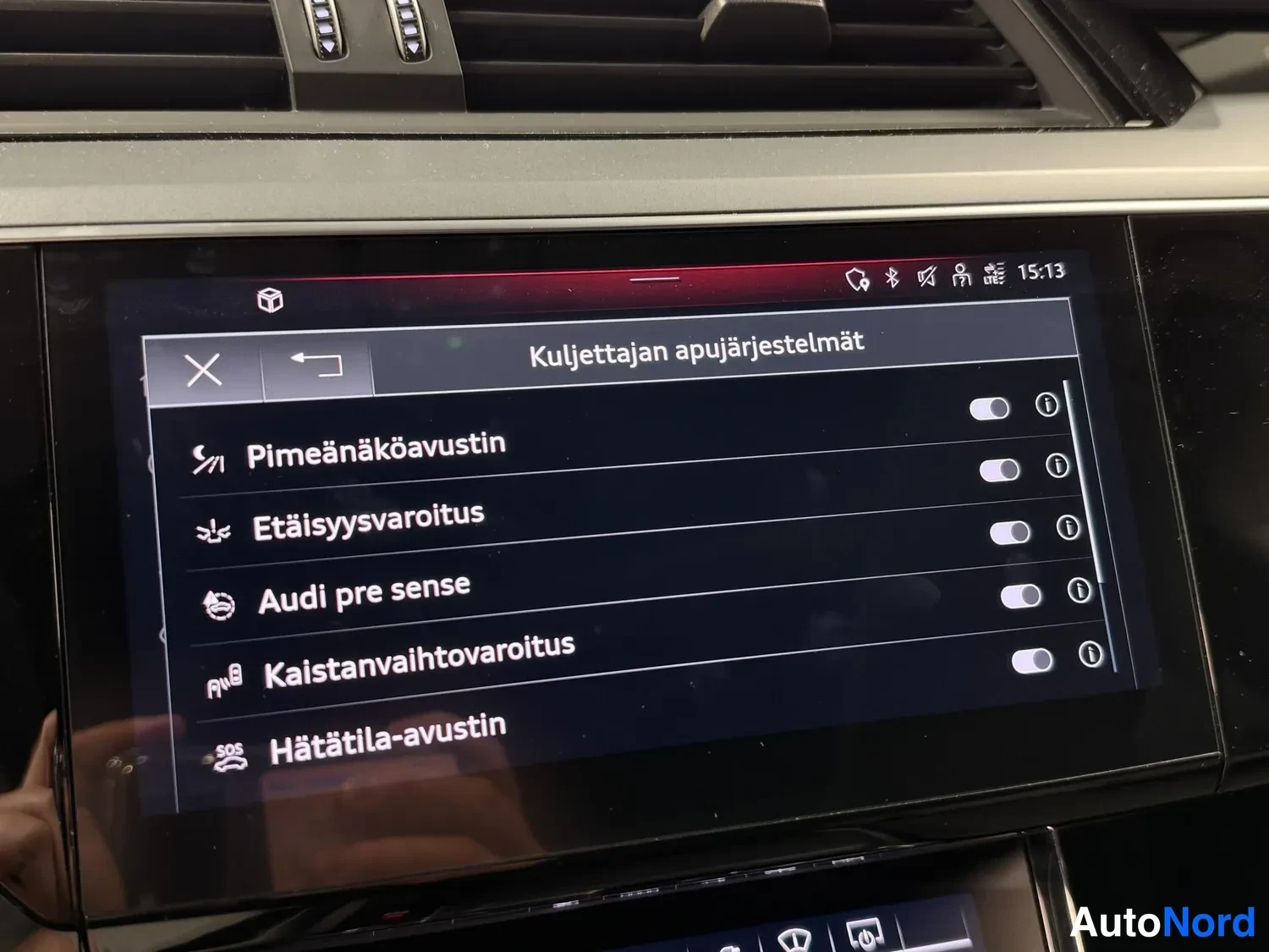 Muu: Näyttö näyttää Kuljettajan apujärjestelmät-valikon, jossa on Pimeänäköavustin, Etäisyysvaroitus, Audi pre sense, Kaistanvaihtovaroitus ja Hätätila-avustin.