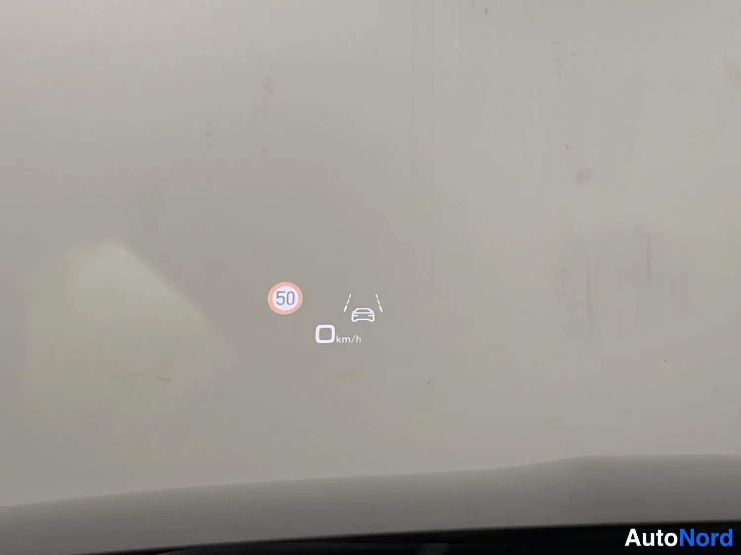 Muu: Head-up-näytön heijastuma tuulilasissa: nopeusrajoitus 50 km/h ja kaistavahti-ikoni.