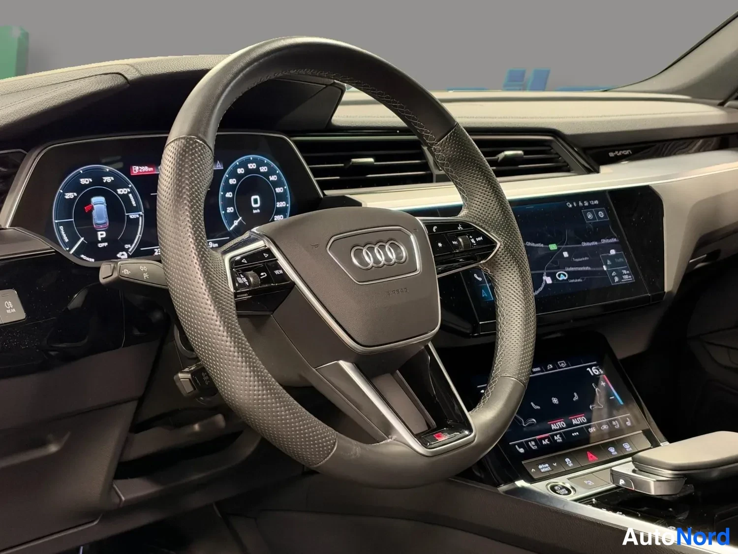 Muu: Ohjaamon nakyama: monitoimiohjauspyyörö Audi-merkillä, digitaalinen mittaristo ja kaksi kosketusnaytoa.