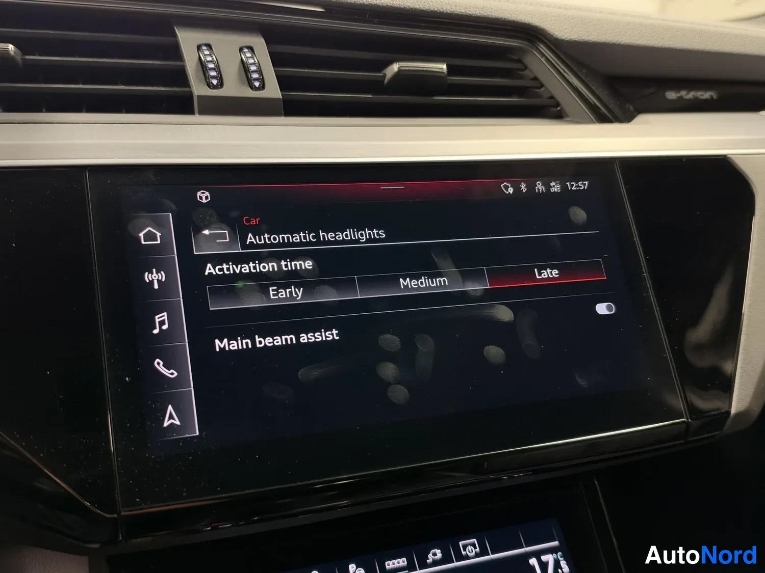 Yksityiskohta: Kojelaudan näyttö valotuksen asetuksissa: 'Automatic headlights' -valikko, aktivointiaika Early / Medium / Late (Late valittuna) sekä 'Main beam assist'.