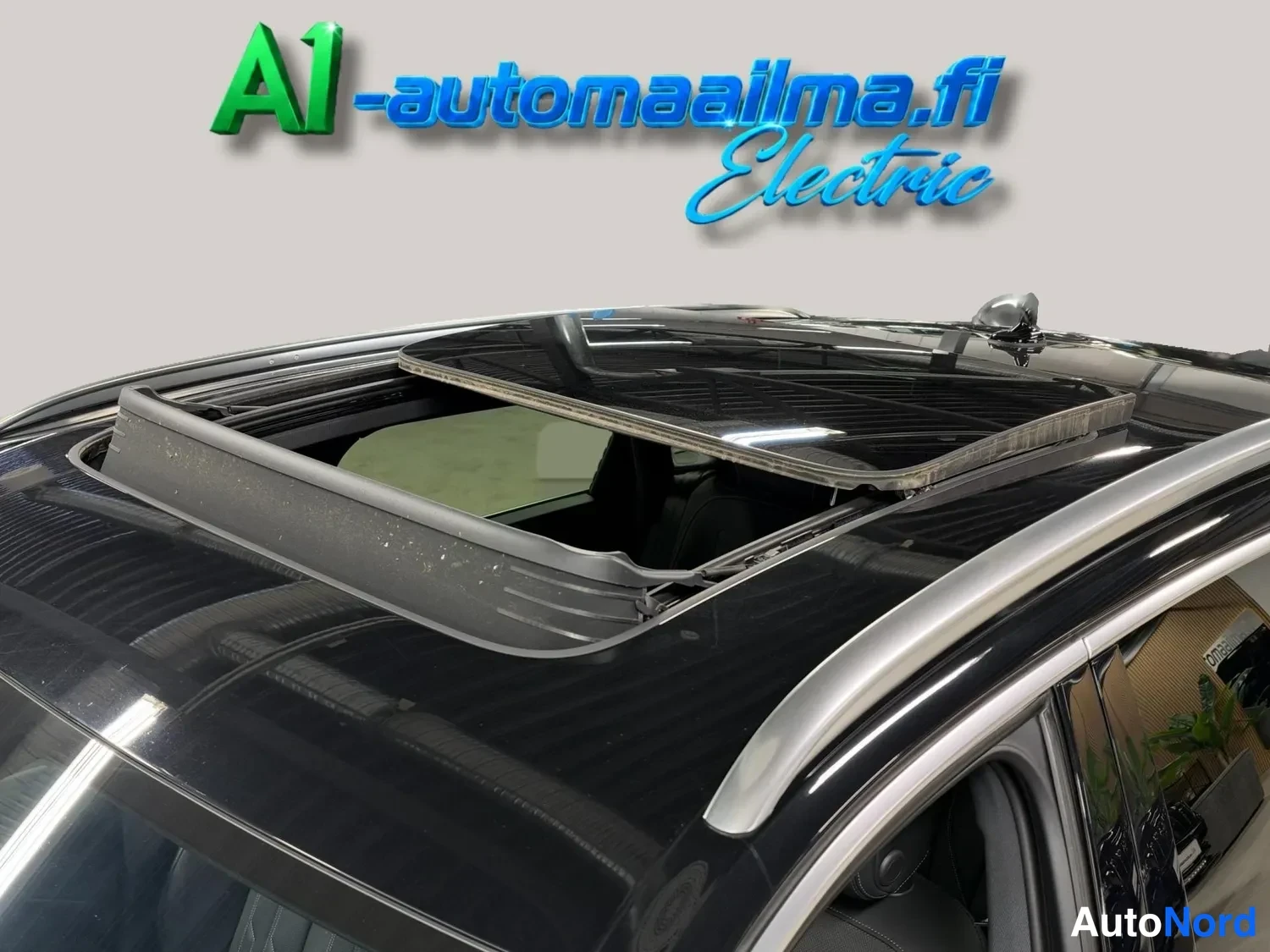 Sivulta: Takaosa avattu panoraamakatto ja kattokaiteet mustalla autolla.
