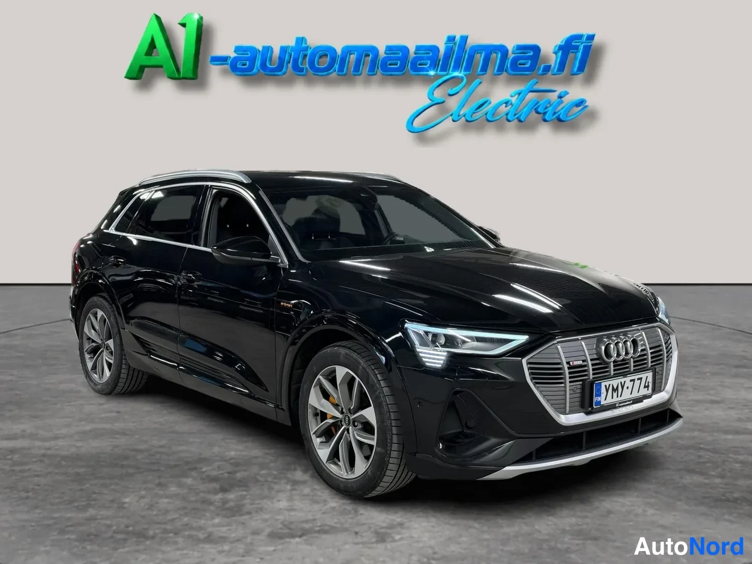 Etuviisto, nokka oikealle: Audi e-tron -maasturin etunurkkakuva oikealta puolta, musta kori, rekisteritunnus.