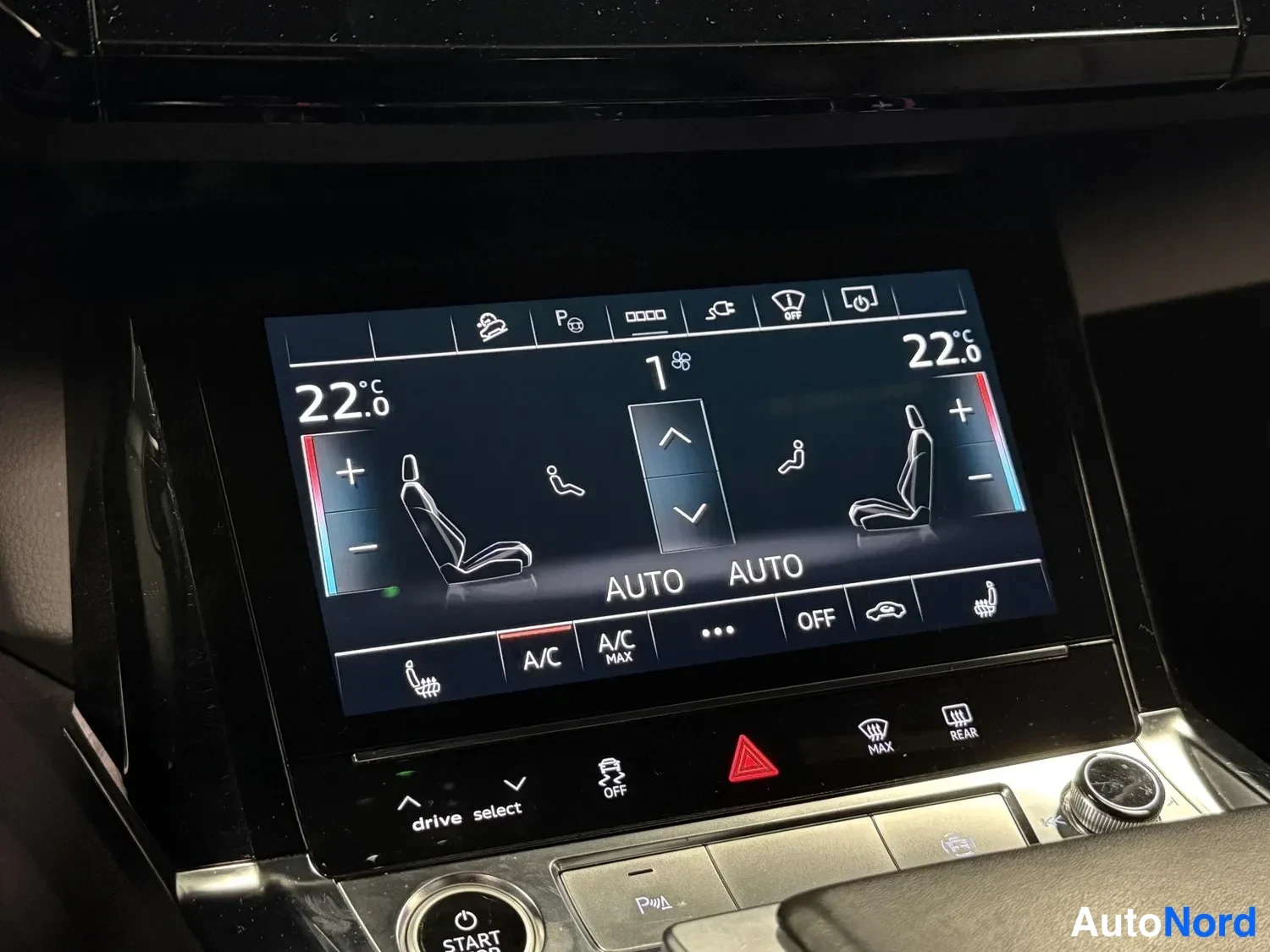 Yksityiskohta: Kojelautaan kazan ilmastointinäyttö näyttää 22,0 °C molemmin puolin ja AUTO-tilat; alla START-nappi ja drive select-asetukset.