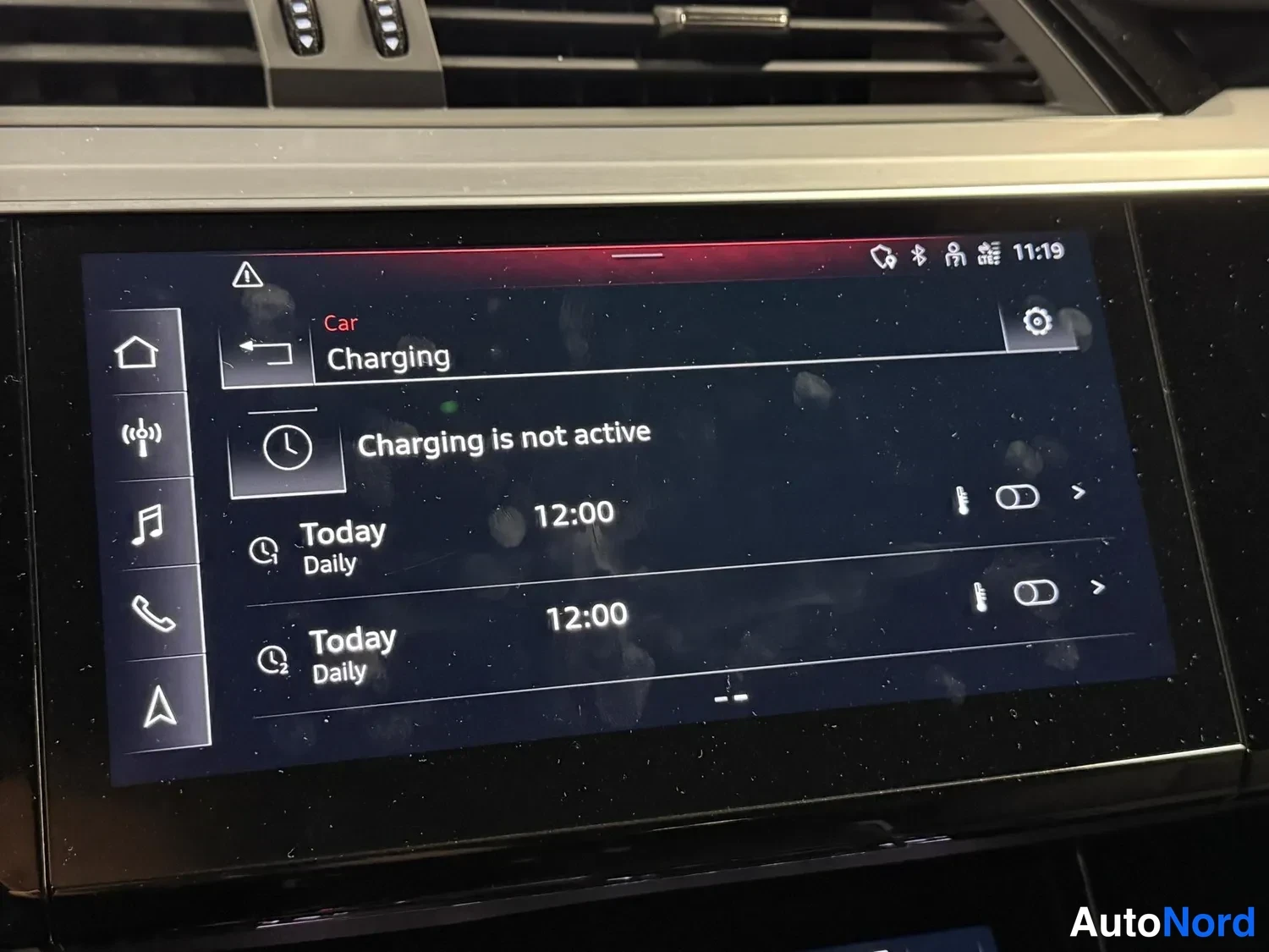 Muu: Kosketusnäytön Charging-näkymä ilmoittaa 'Charging is not active' ja näyttää kaksi päivittäistä latausaikataulua kello 12:00.