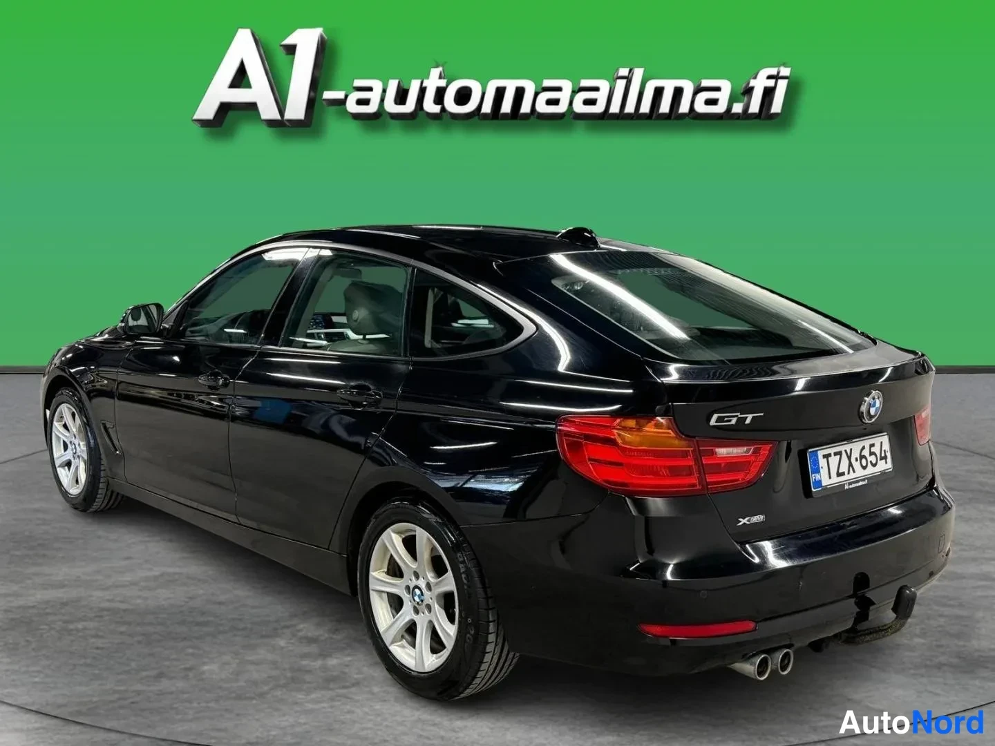 Takaviisto: Mustan BMW:n takakulmanäyttö vasemmalta: ovenlinjat, takapovi, GT-merkintä, -rekisterikilpi, kaksoispakoputki ja vetokoukku.