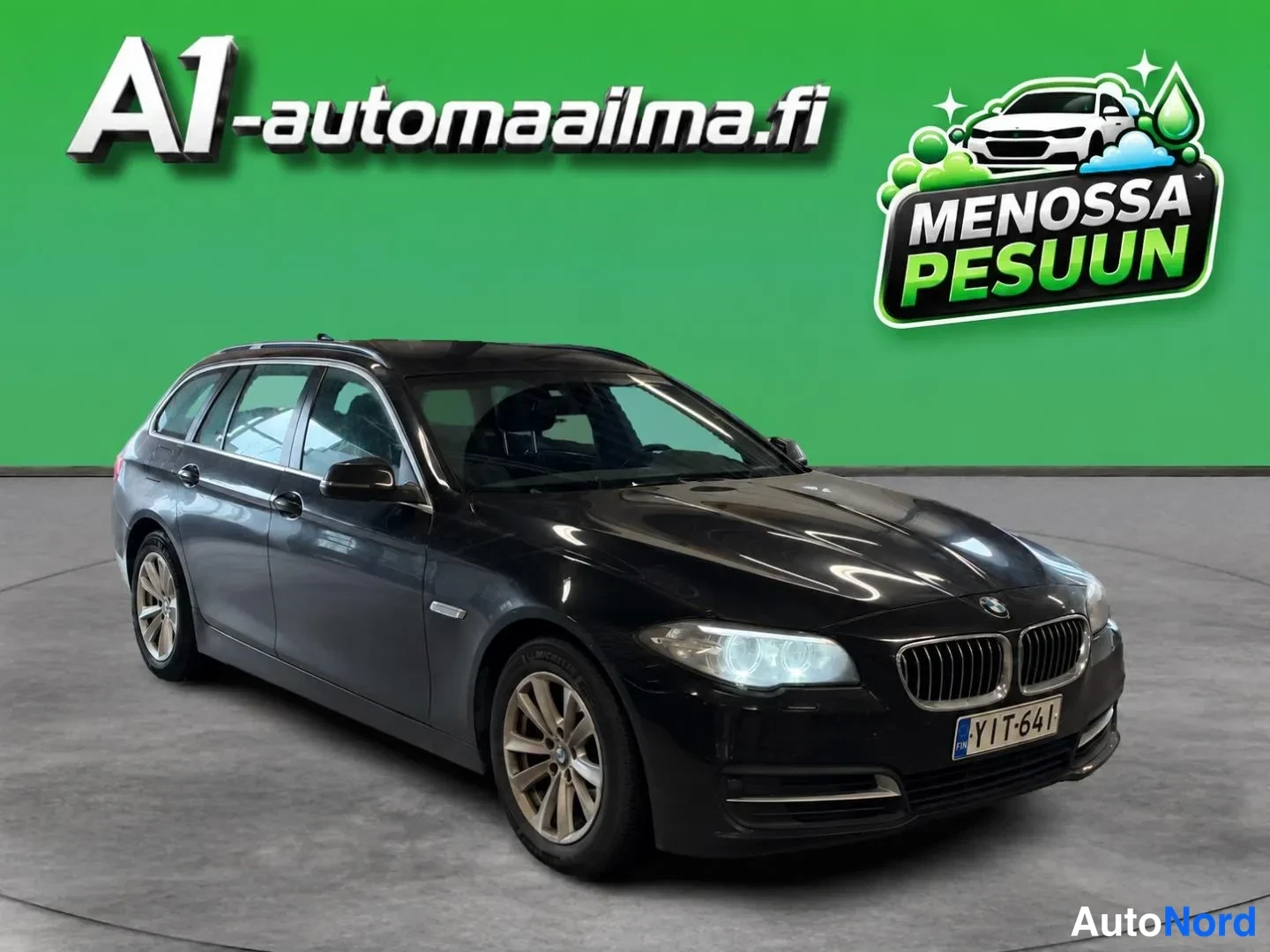 Etuviisto, nokka oikealle: Musta BMW-farmari etuviistöstä oikealta kuvattuna, rekisterikilpi.