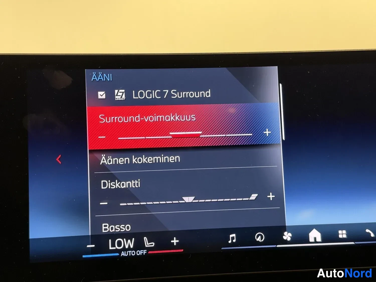 Muu: Auton Kakshintaaninfotainment-näyttö näkyvästä AÄNI-valikosta, jossa valittuna LOGIC 7 Surround ja Surround-voimakkuus-säädin; alla Äänen kokeminen, Diskantti j