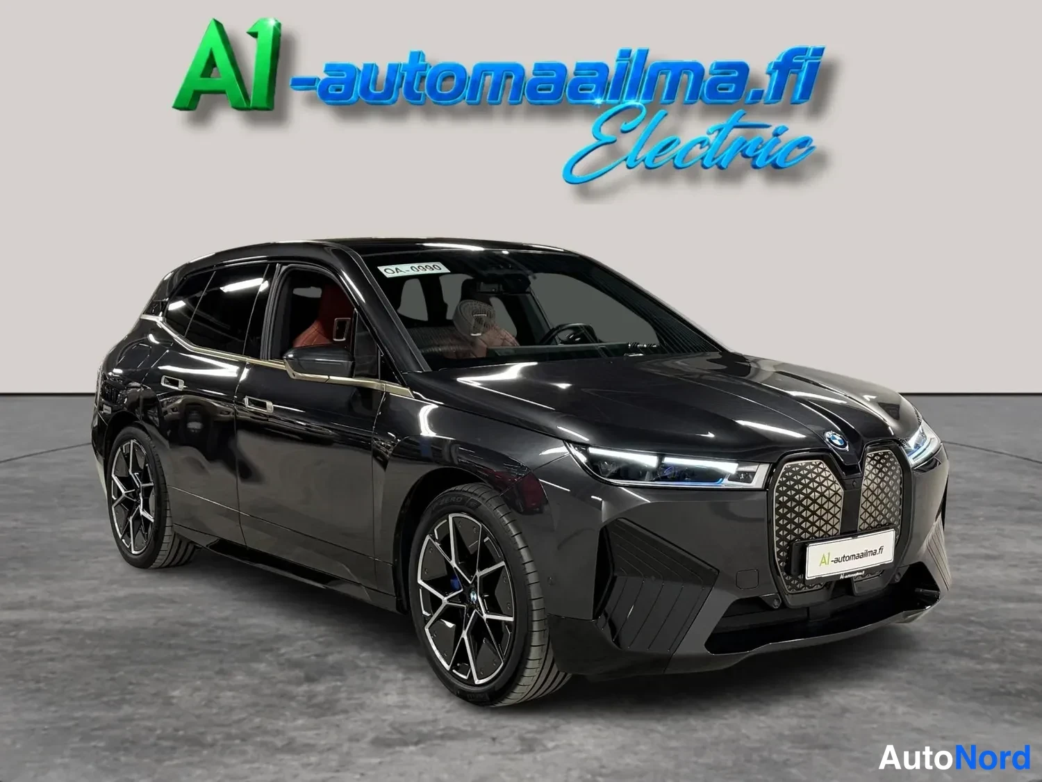Etuviisto, nokka oikealle: BMW iX, tummanharmaa etukulmakuva oikealta, urheilulliset kevytmetallivanteet.