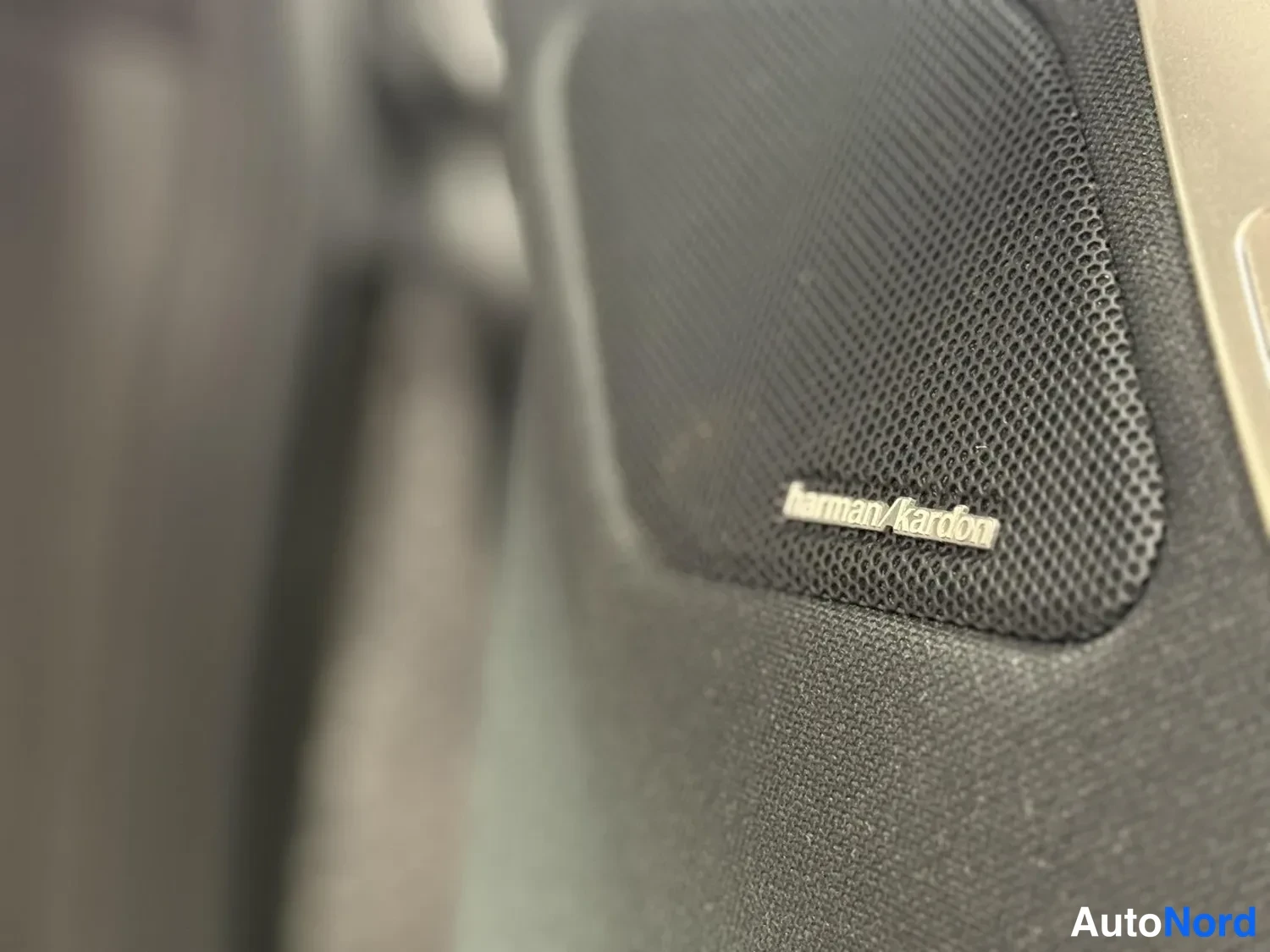 Muu: Sisätilan käsinäyttö: harmaa kaiutinelementti, johon on kiinnitetty harman/kardon -merkki.