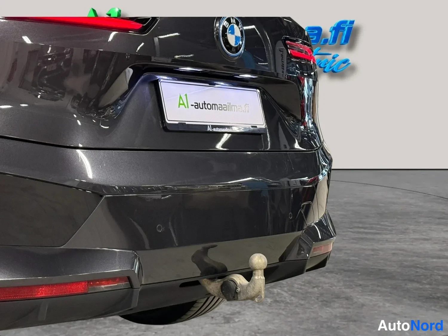 Takaa: Lähikuva auton takapuskurista: säädettävä vetokoukku irrotettuna paikaltaan, BMW-merkki ja A1-automaaailma.fi-kyltti.
