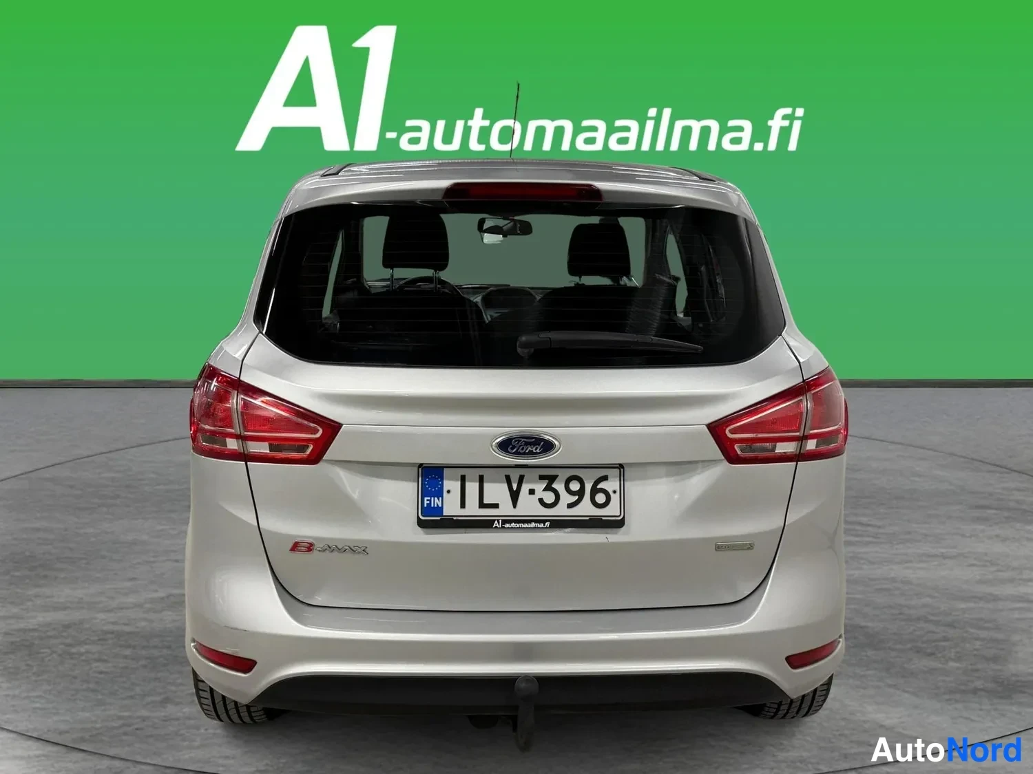 Takaa: Suora takanäkymä hopeanvärisestä Ford B-Maxista, rekisterikilpi, sähköistettava takaluukku ja telinekytkin näkyvissä.