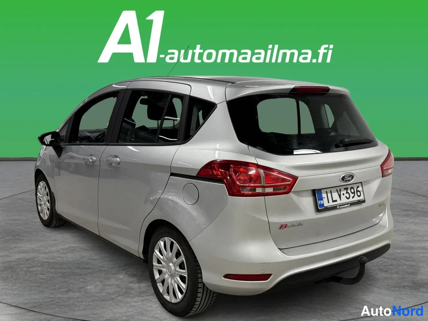 Takaviisto: Hopeanvärisen Ford B-Maxin takakulma vasemmalta, rekisterikilpi, tankkausluukku ja telinekytkin näkyvissä.