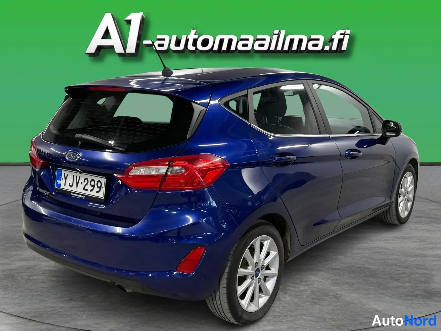 Takaviisto: Sininen Ford Fiesta -henkilöauto takakulmasta vasemmalta, rekisteritunnus.