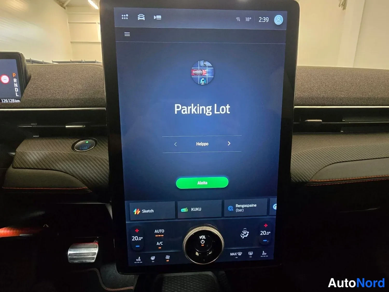 Muu: Auton suuri pystyyn asennettu kosketusnäyttö näyttää ''Parking Lot'' -näkymän ja alle valittuja sovelluksia, kuten Sketch, KUKU ja Rengaspaine (bar).