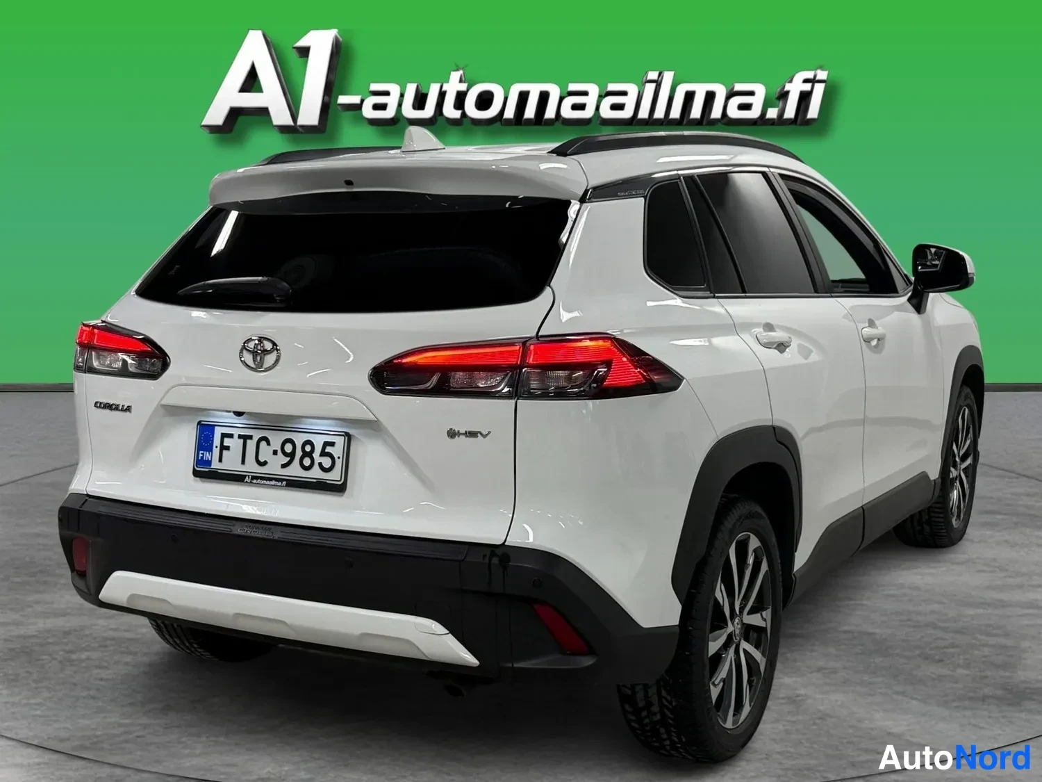 Takaviisto: Valkoisen Toyota Corolla Crossin takakolmannes-näkymä, rekisterikilpi.