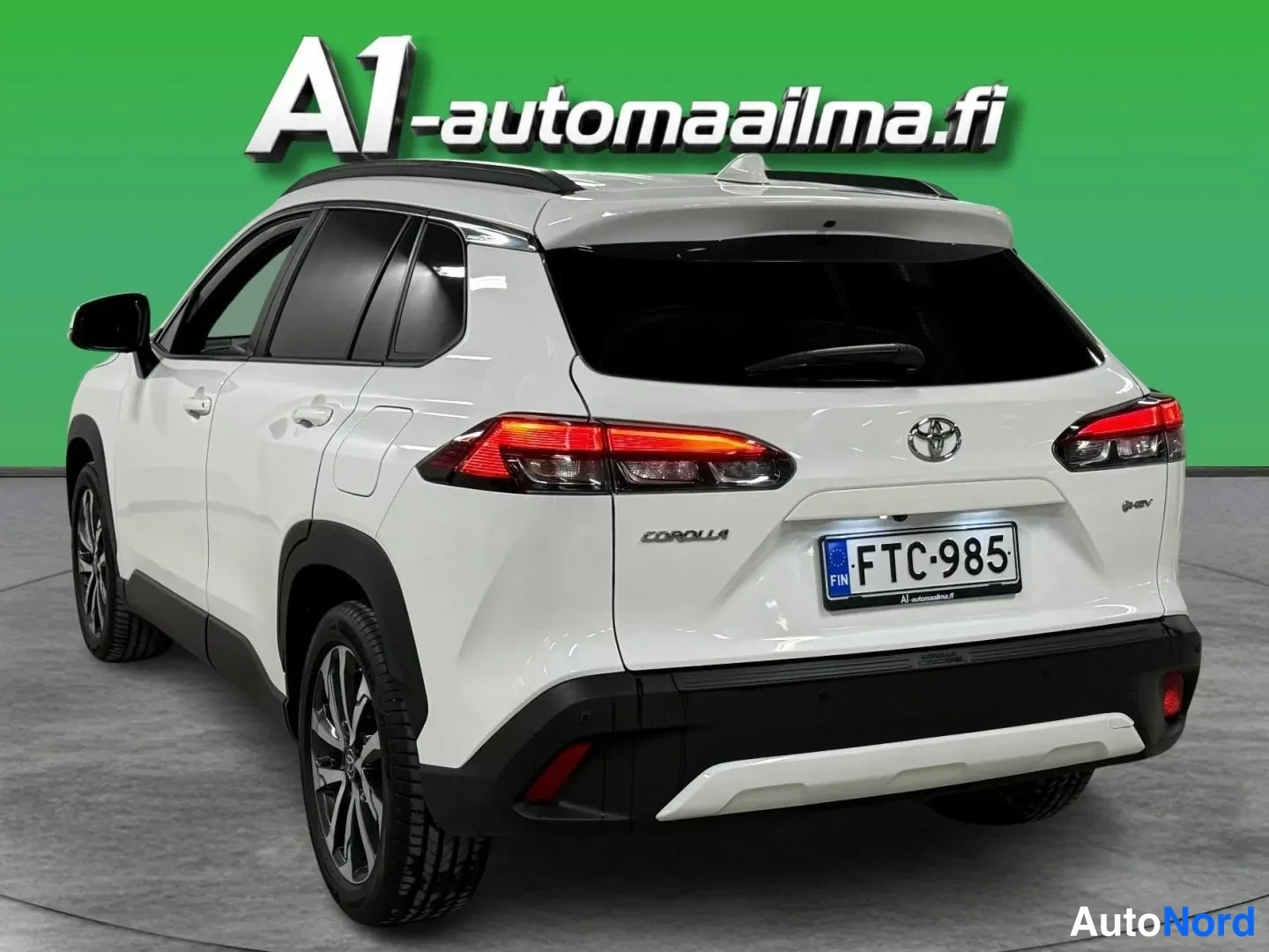 Takaviisto: Toyota Corolla Crossin takaosa kolmannesnurkasta; valkoinen korimuovi, kattotankoteline, takavalo ja rekisteritunnus näkyvät.