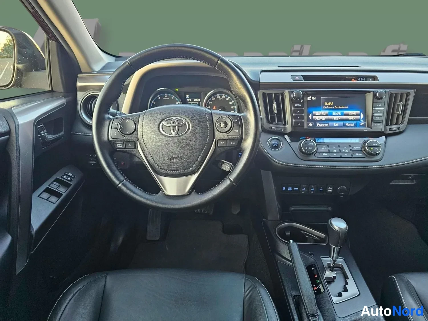 Muu: Kuljettajan näkökulma ohjaamoon: Toyota-ohjauspyörä, mittaristo, keskinäytön radio ja automaattivaihteen valitsin.