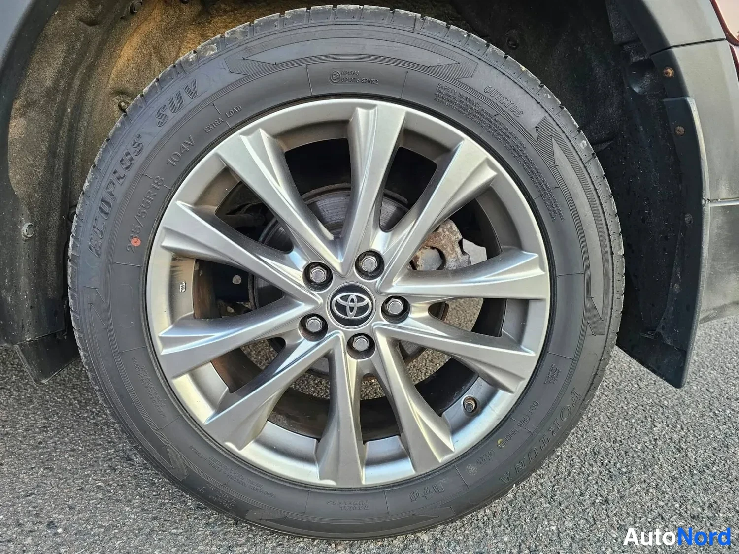 Yksityiskohta: Toyota-merkkinen hopeiseosvanteen keskiössä, rengassa LECPPLUS SUV-teksti, jarrulevy näkyy vanteen läpi.