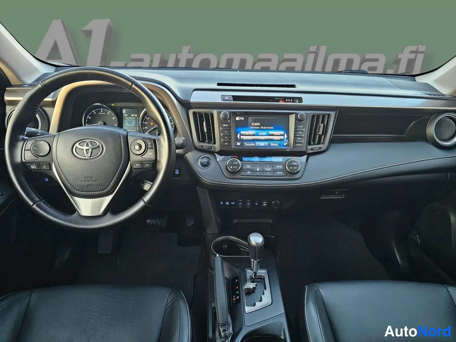 Muu: Ohjaamo etu­tasosta: Toyota-ohjauspyörä, kojelaudan mittarit, kosketusnäytöllinen radio ja automaattivaihteen valitsin.