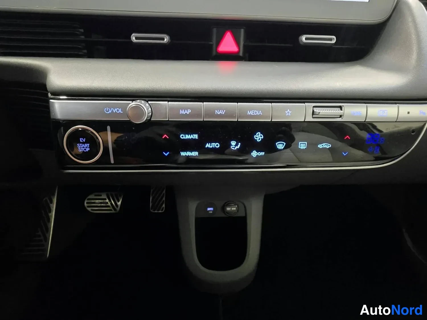 Edestä: Kojelaudan keskirivi: EV START STOP -painike, äänenvoimakkuussäädin, MAP/NAV/MEDIA-napit ja ilmastoinnin CLIMATE AUTO WARMER -ohjaimet; alla USB-portti ja 12V-p