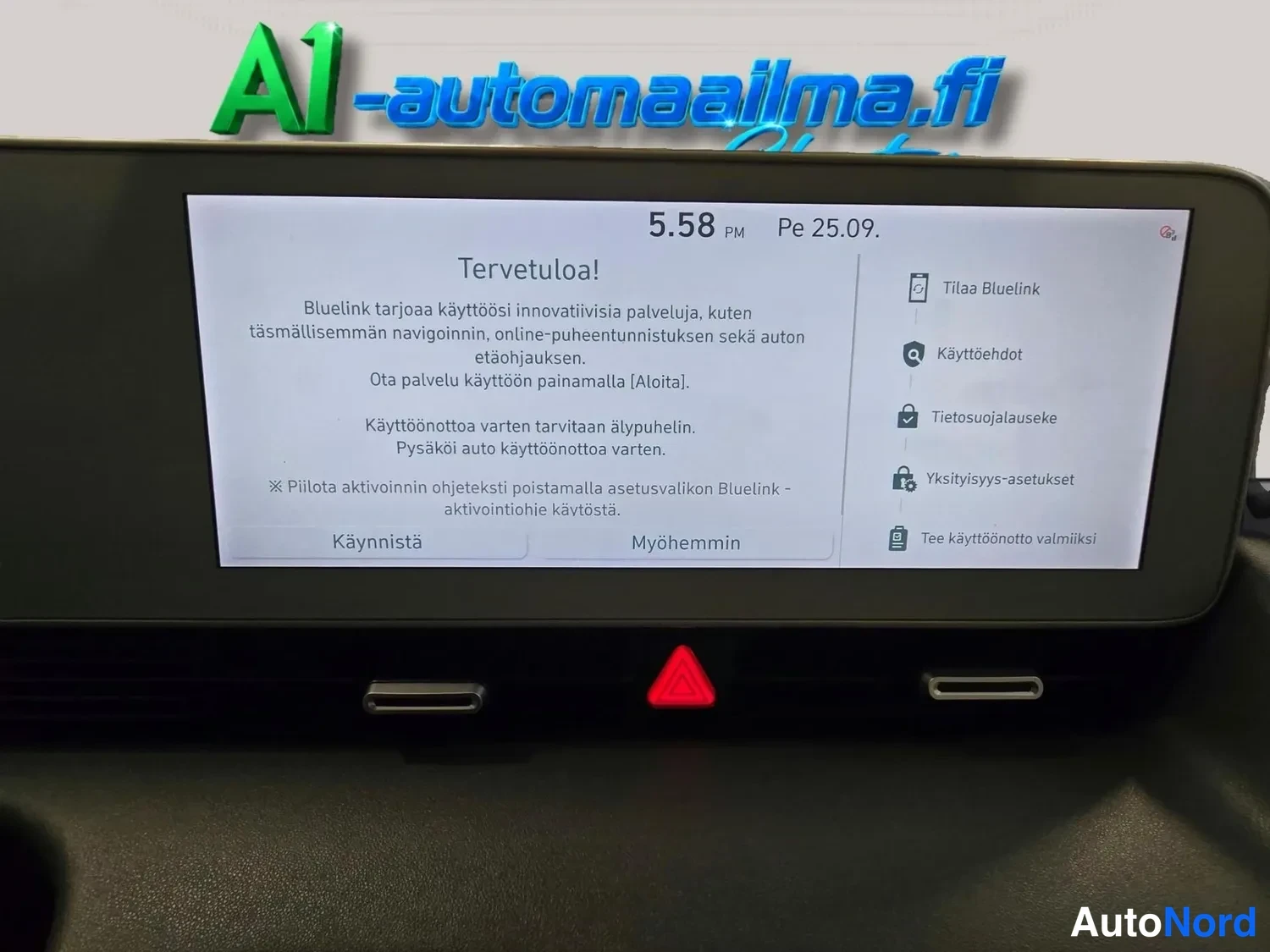 Edestä: Infotainment-näyttö näyttää 'Tervetuloa!'-käyttöönottoikkunan, jossa Bluelink-palvelun kuvaus, vaihtoehdot Käynnistä ja Myöhemmin sekä oikealla valikko Tilaa Bl