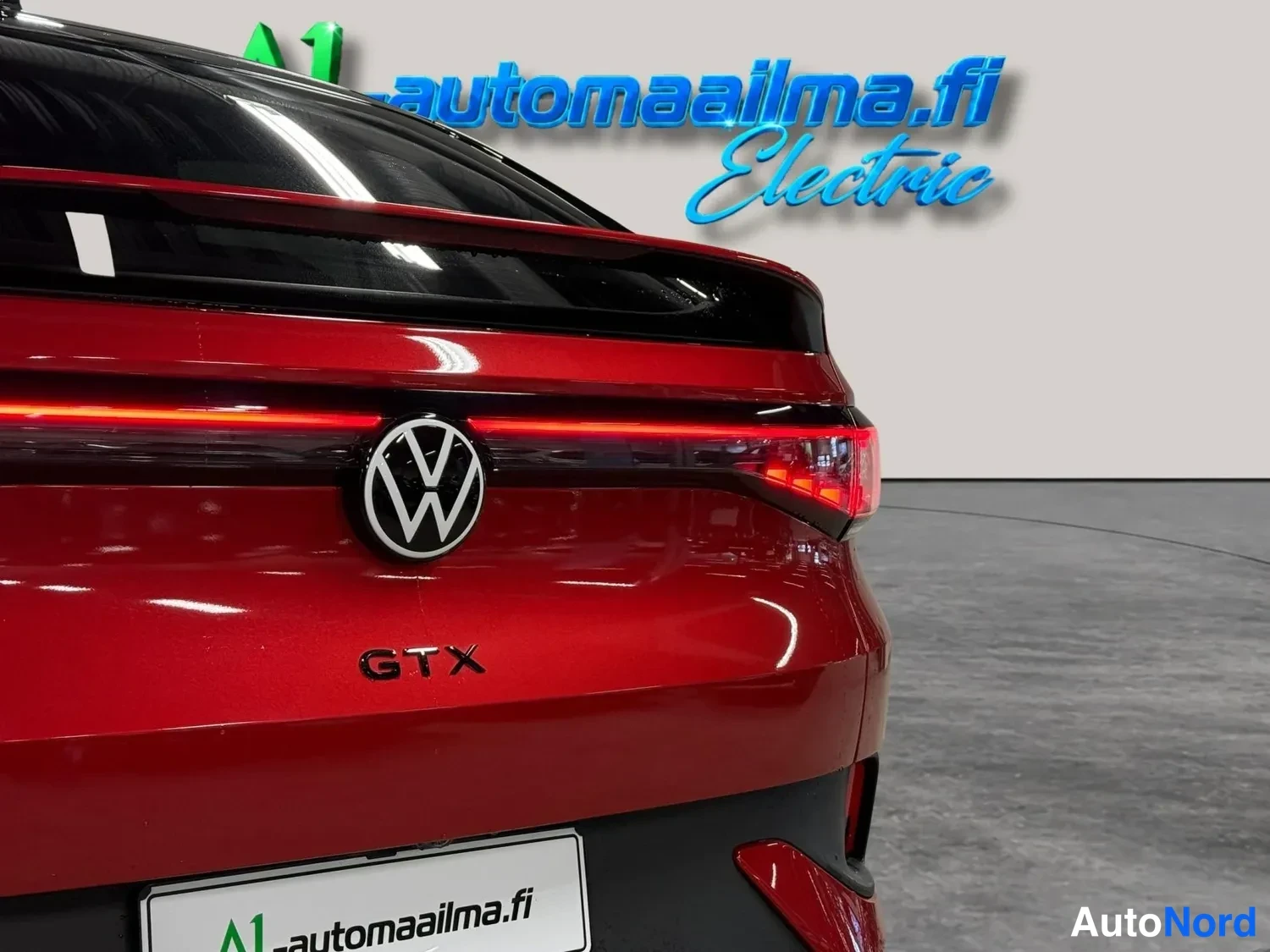 Takaa: Lähikuva punaisen Volkswagenin takaa: VW-merkki, GTX-merkintä ja osa poikittaisesta takavalosta näkyvät tarkasti.