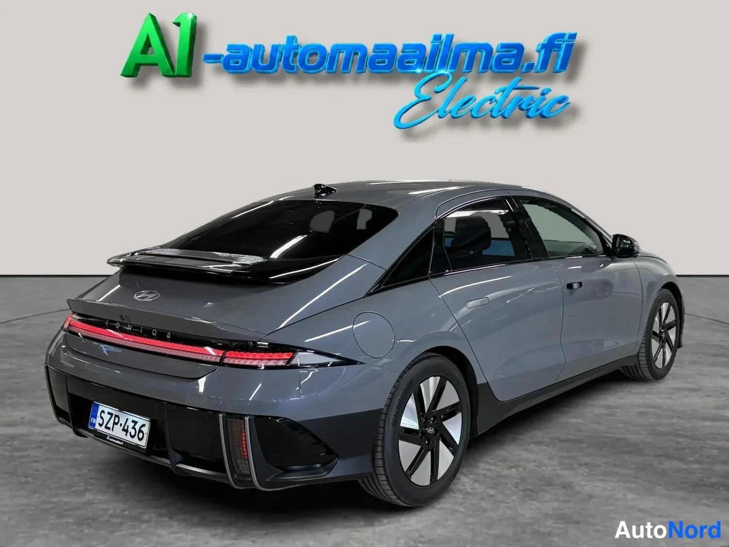 Takaviisto: Takahärmä autosta: tummanharmaa sedan, punainen takavalo, musta spoileri ja mustat vanteet.