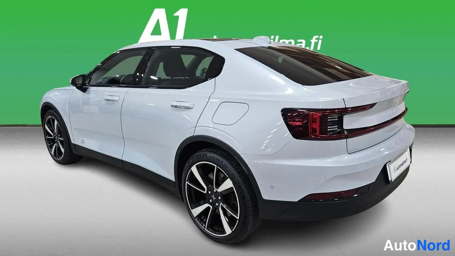 Takaviisto: Polestar 2:n takakulmanäkyvä oikealta, valkoinen kori ja tummat kevytmetallivanteet.