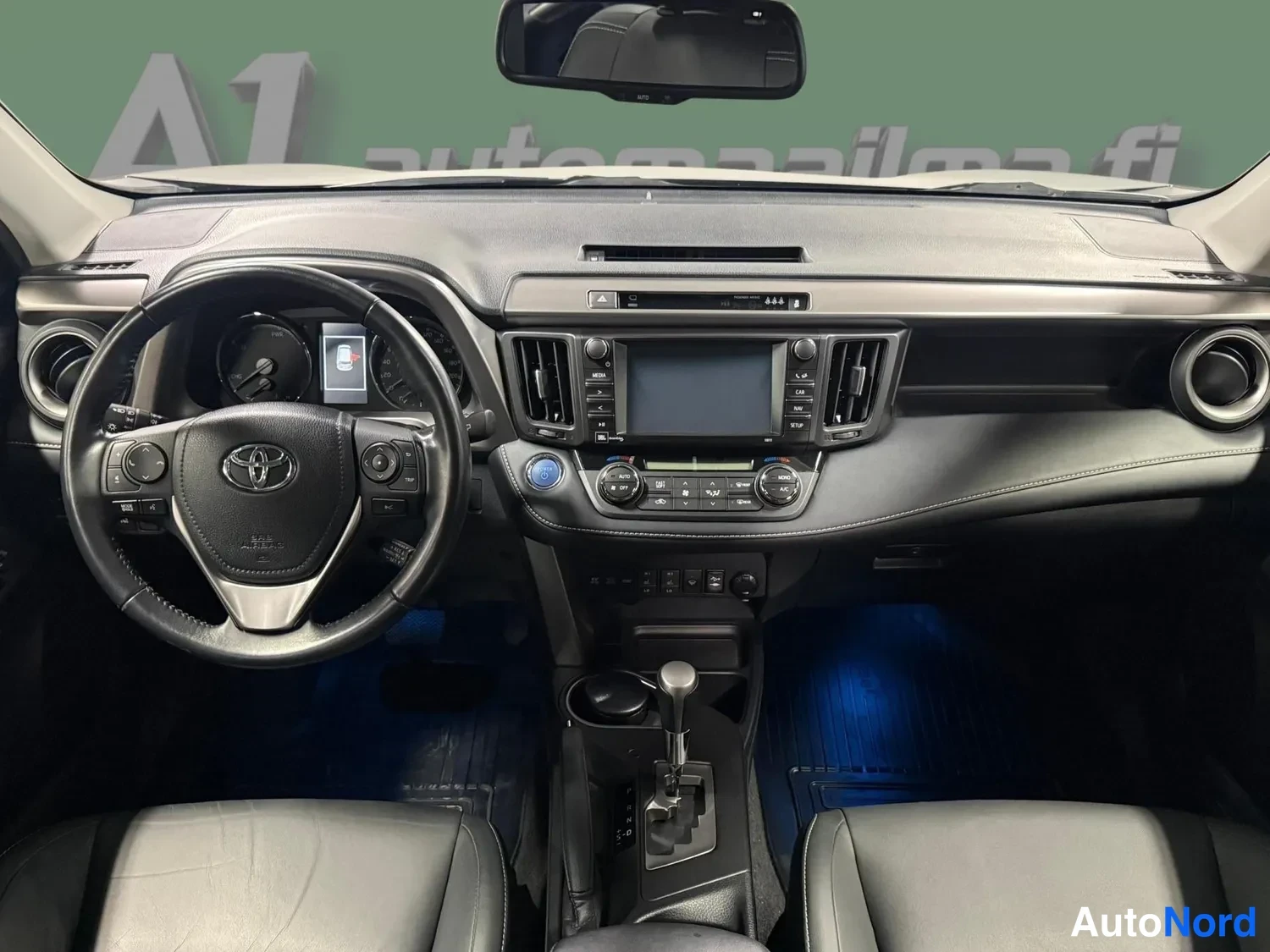 Muu: Ohjaamo etupuolelta: Toyota-merkkinen ohjauspyörä, kojelauta, keskikonsoli ja kaksi etuistuinta.