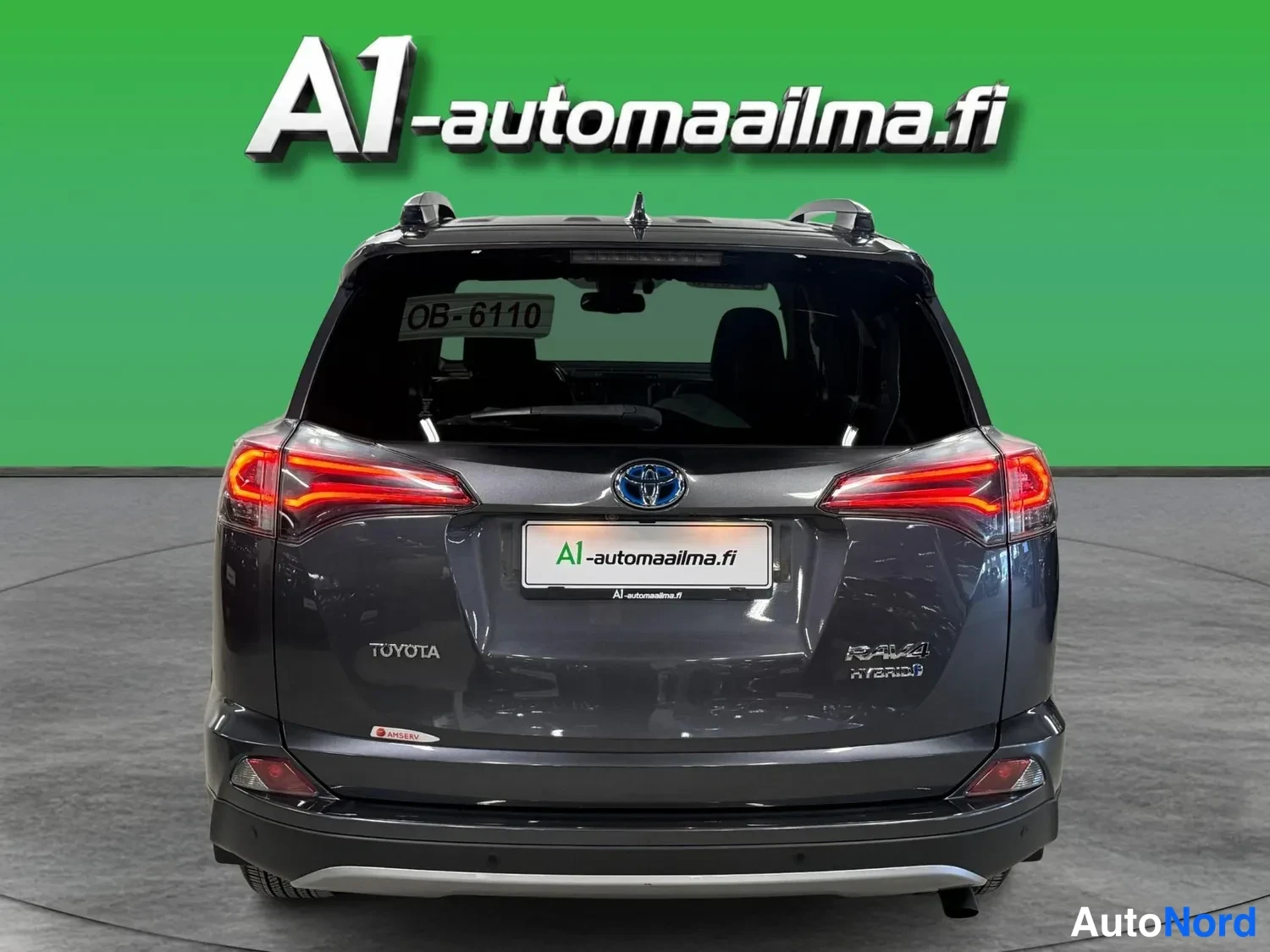 Takaa: Auton takaosan suorakuva: tummanharmaa Toyota RAV4 Hybrid,Toyota-merkintä takaluukissa, punaiset takavalot ja rekisterikilpi OB-6110.