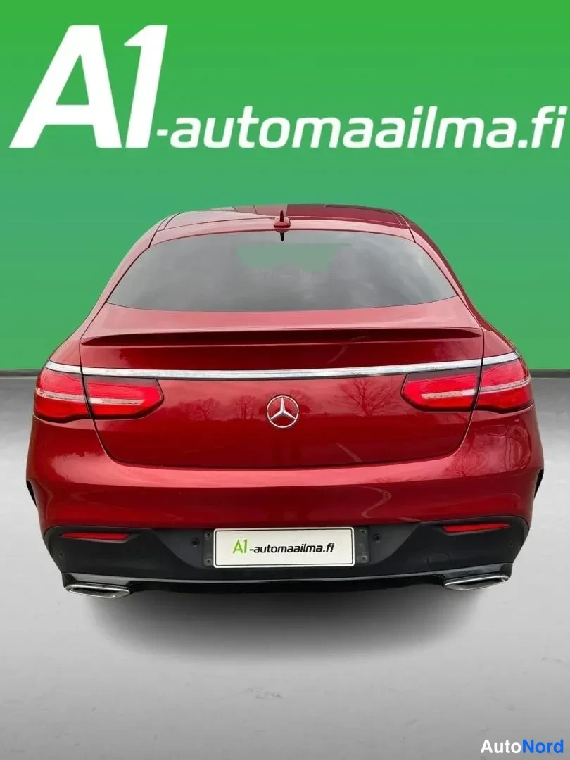 Takaa: Punainen Mercedes-Benz GLE Coupé suoraan takaa, takavalojen väliin sijoittuva merkki ja airot näkyvissä.